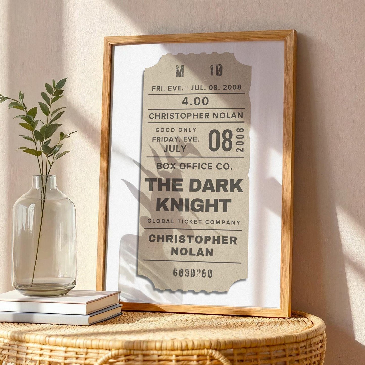 wall art in oak frame on table. The art is beige with custom text written on a old vintage film event pass.