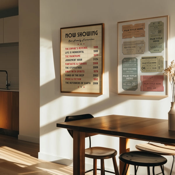 Two large prints framed on the wall in a dining room. The art is inspired by retro cinema letterboards and vintage ticket stubs.