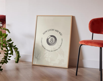 Minimalist lyric print with retro eight ball and “how lucky are we,” lyric perfect for country home or music space.