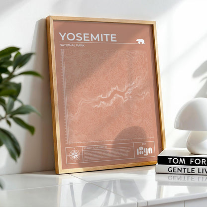Framed Yosemite topographic map art leaning on desk, perfect gift for hikers and nature lovers.