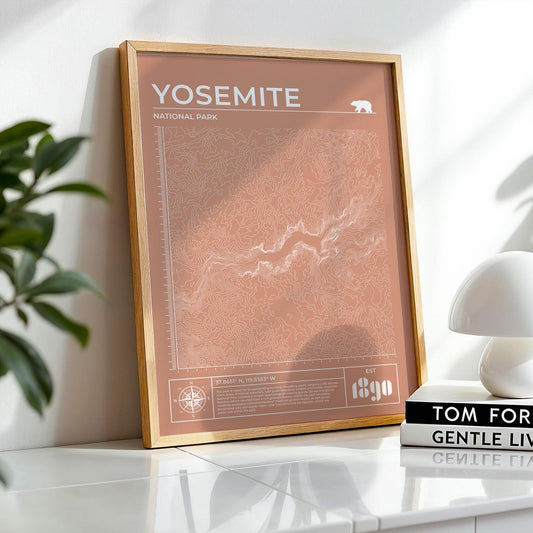 Framed Yosemite topographic map art leaning on desk, perfect gift for hikers and nature lovers.