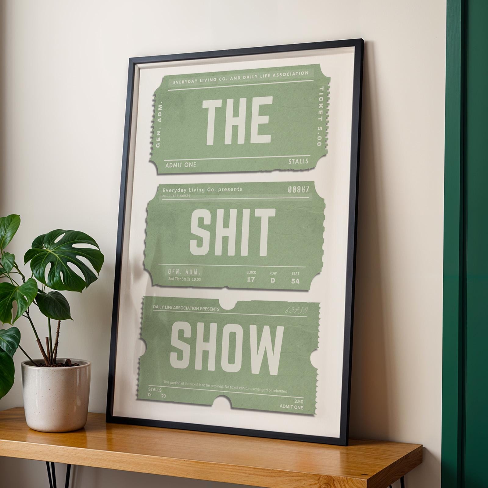 Green retro ticket stub poster leaning on wall in black frame.