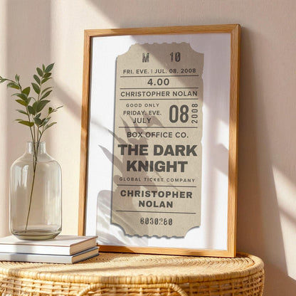 wall art in oak frame on table. The art is beige with custom text written on a old vintage film event pass.