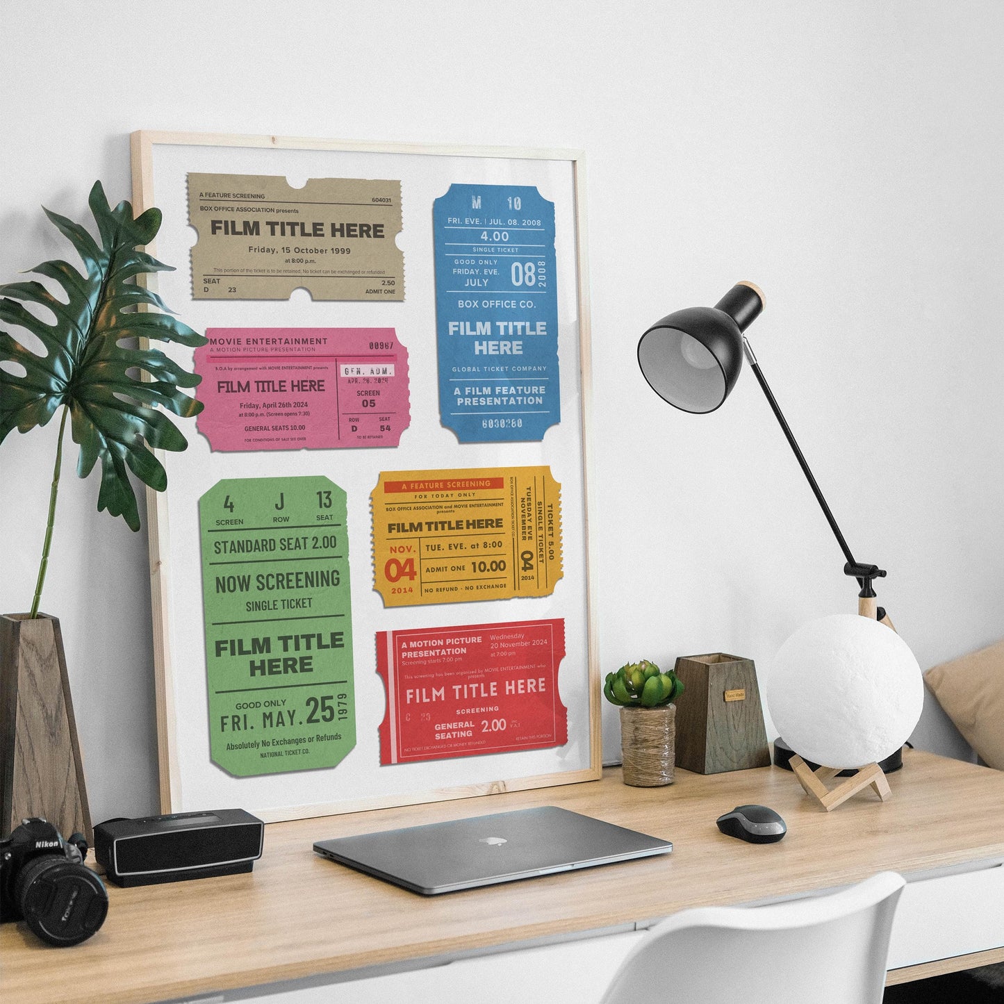 a manly desk setup at home with old ticket stubs art framed on wall.