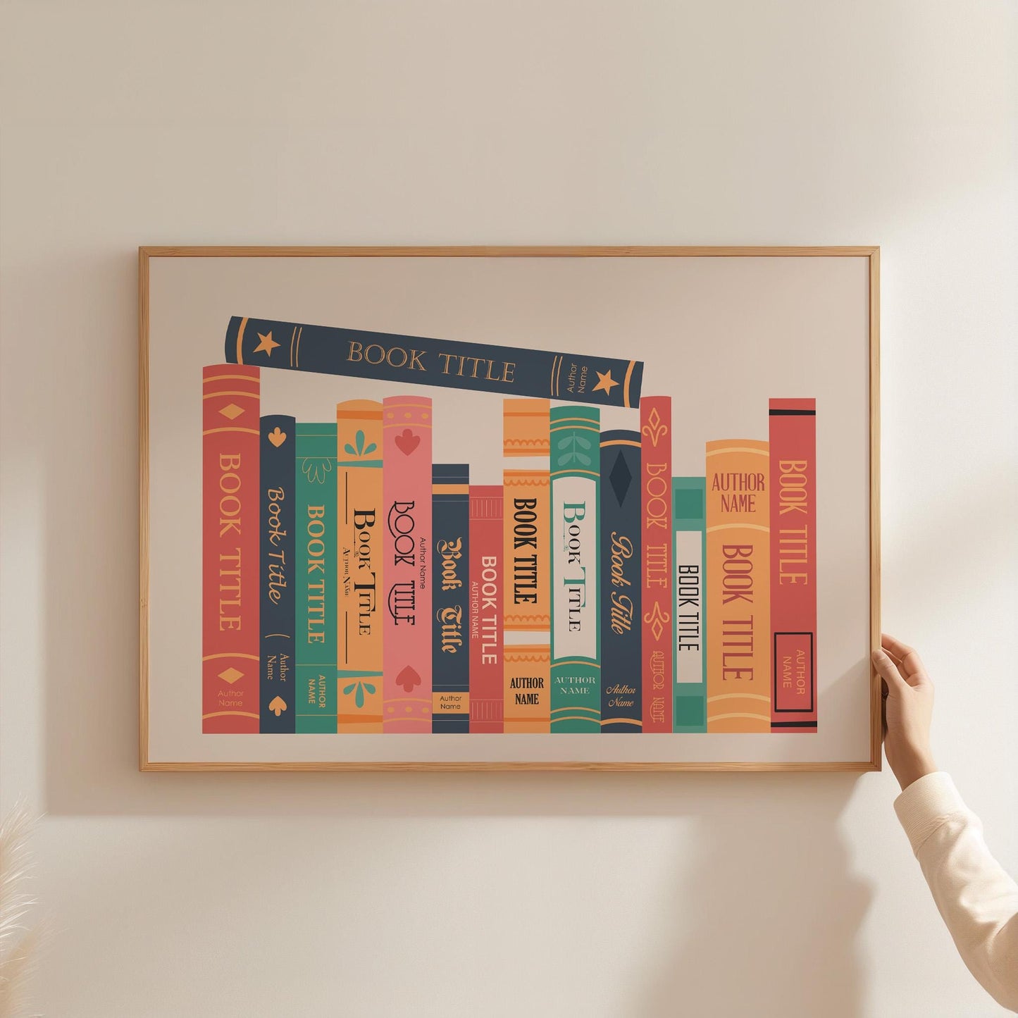 A colourful personalised print being held up in a frame on wall. The art features bespoke book titles in a custom design style.