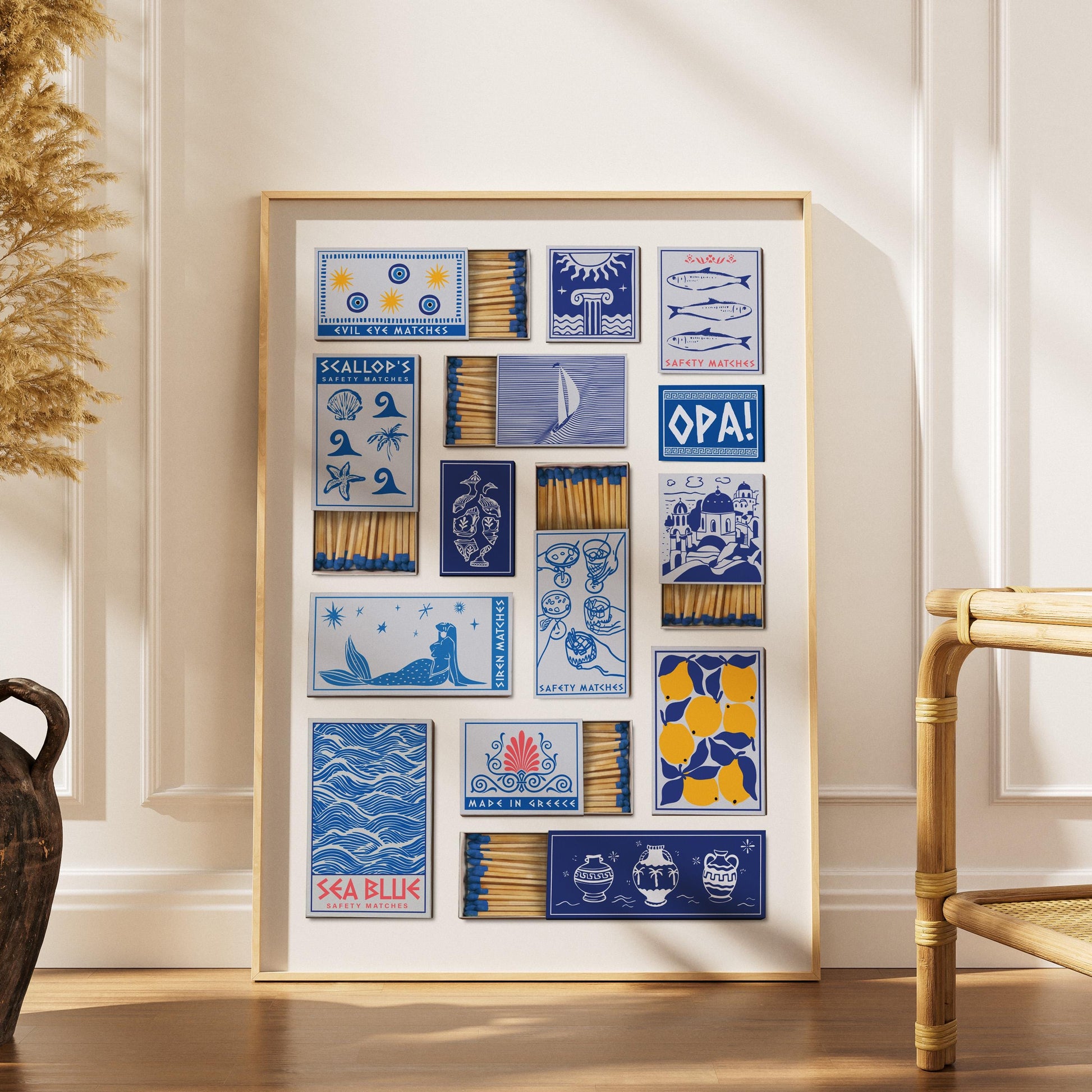 An eclectic art piece showcasing matchbox designs in blue and white, with illustrations of lemons and Greek motifs. The text includes "Siren Matches". The matches are visible within the boxes.
