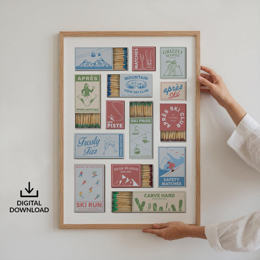 A framed print displaying a printable design of a collection of matchbox designs with ski-related imagery and text. The matchboxes are in blue, red, and green, with phrases such as "Après Ski," "Ski Run," and "Carve Hard." The print is held by a person.