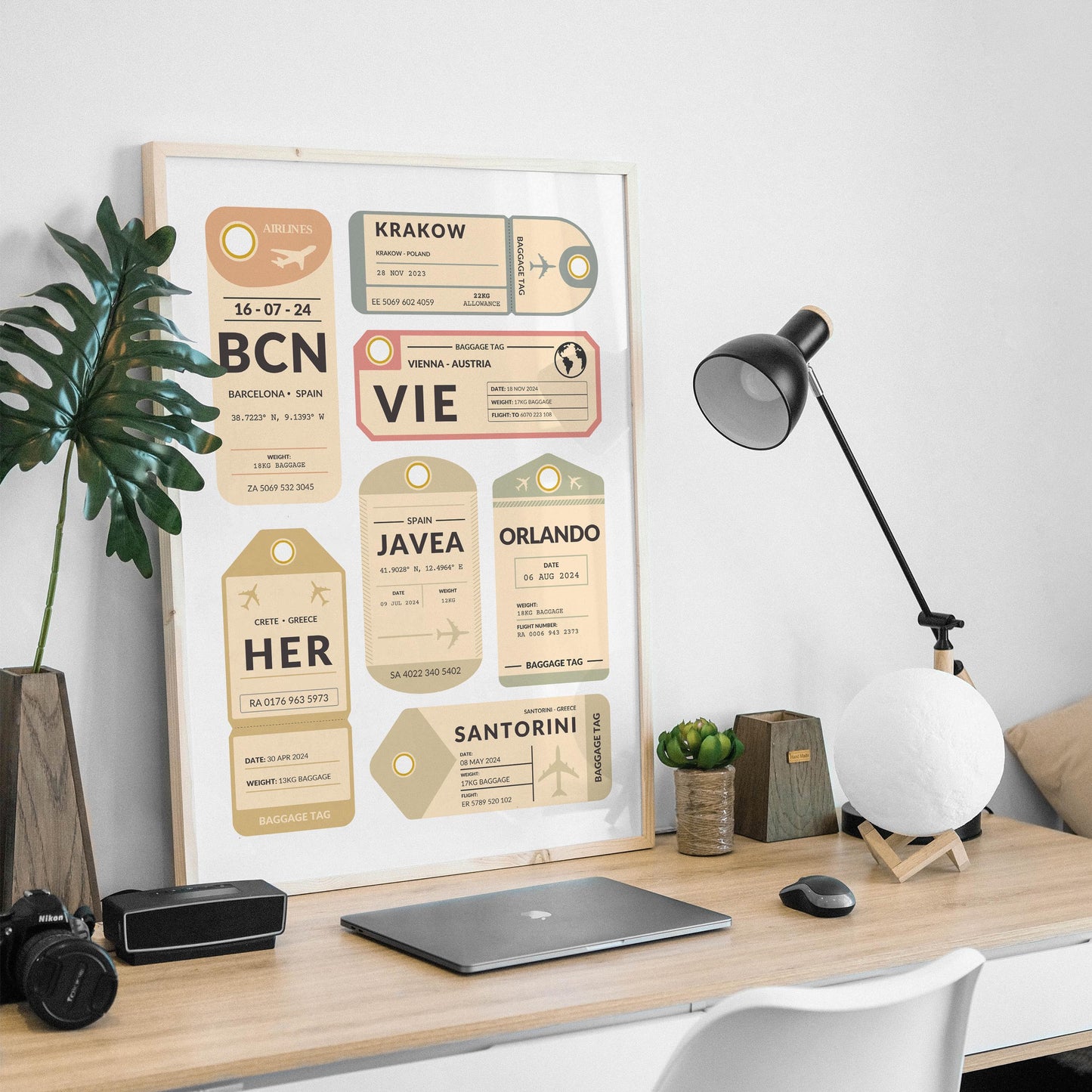 masculine desk at home with plant and black lamp. wood frame containing a bespoke made print design featuring retro luggage tags with details of personal travels and dates.
