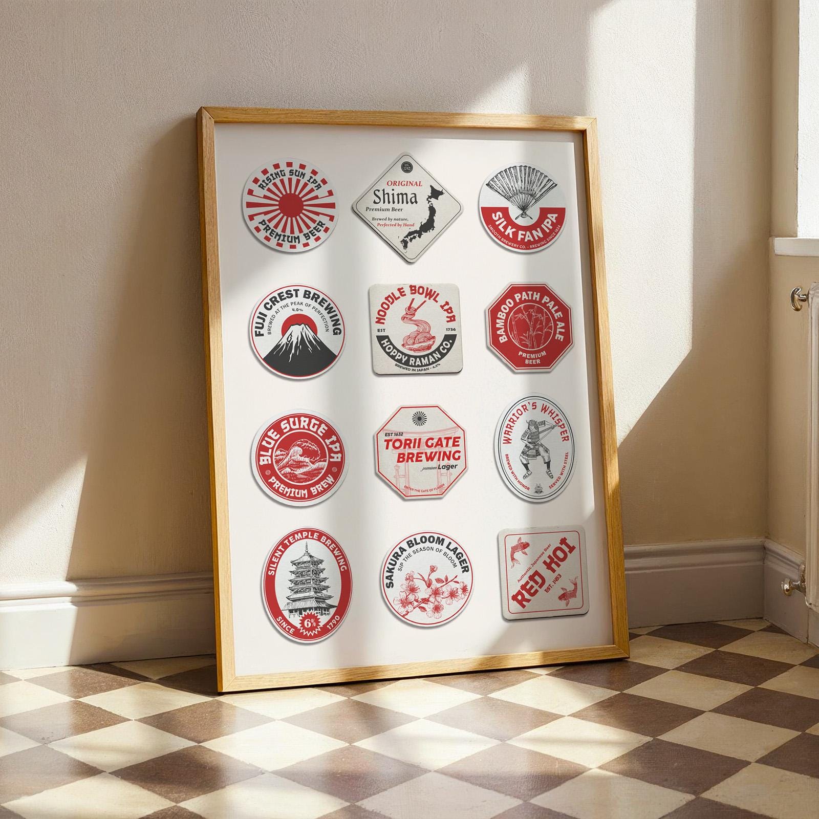 a checkered floor in a kitchen with a print leaning on the white wall. Japanese motifs on travel inspired beer mats are on the design featuring reds, white and black colour schemes.