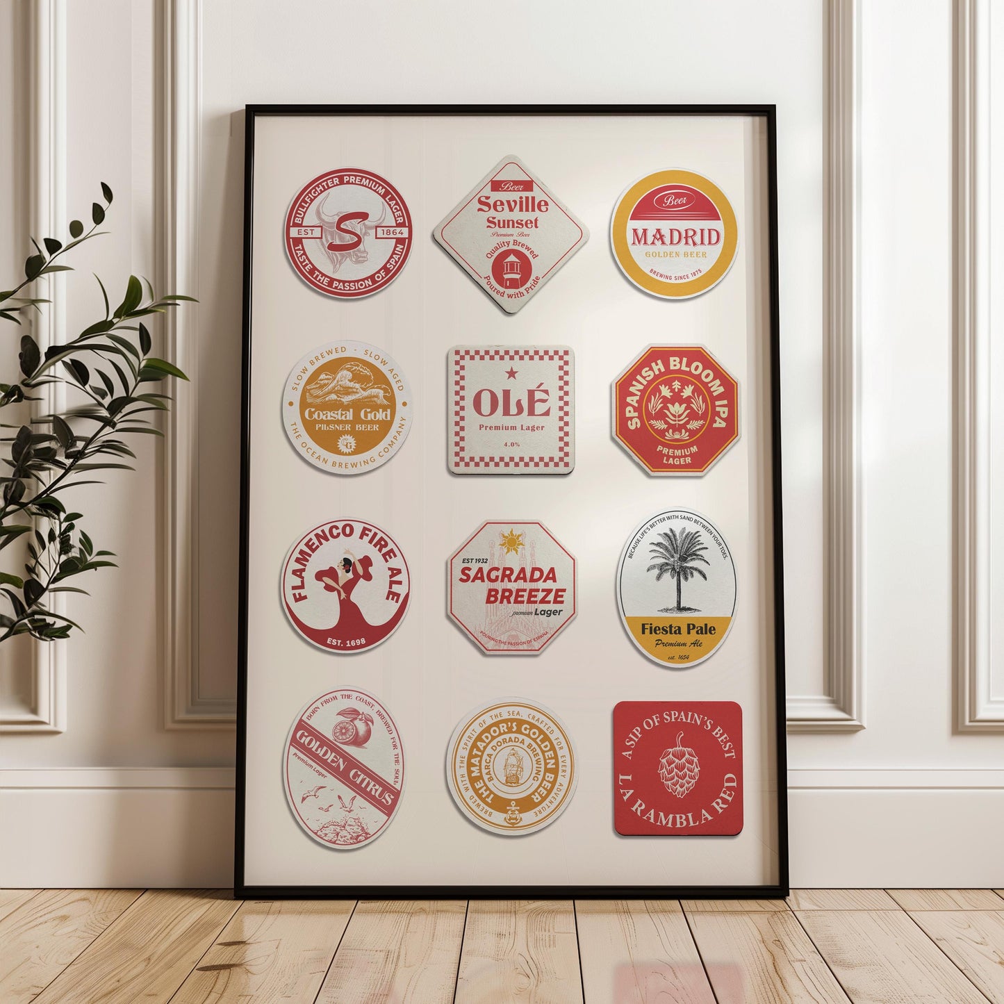 a hallway in a home with wood floors and white modern walls. A poster in a black frame leaning on the wall showing spanish themes and icons such as the sagrada familia and flamenco dancers on retro beer coasters.