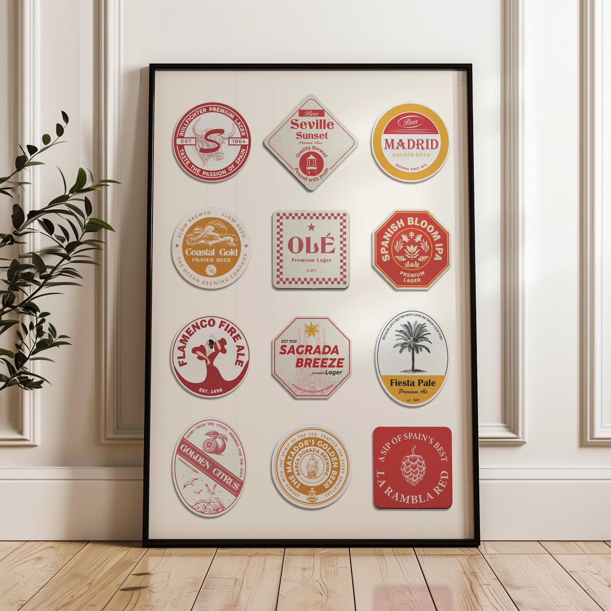 a hallway in a home with wood floors and white modern walls. A poster in a black frame leaning on the wall showing spanish themes and icons such as the sagrada familia and flamenco dancers on retro beer coasters.
