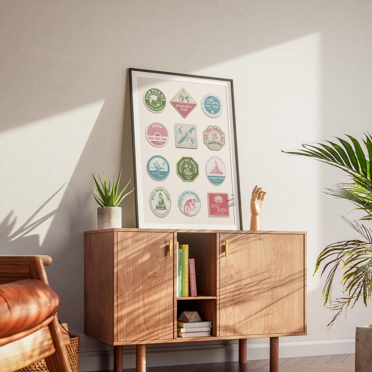 a mid century modern home showing a eclectic art print inspired by travels in thailand. The art shows retro beer mat designs with thai icons and themes in pinks, blue and green.