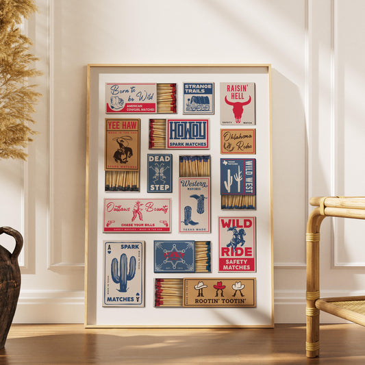 A framed print displaying a collection of vintage-style matchbox designs with Western and cowboy themes. The matchbooks feature text and illustrations, including cacti, boots, and cowboy hats. The color scheme includes red, blue, and brown.
