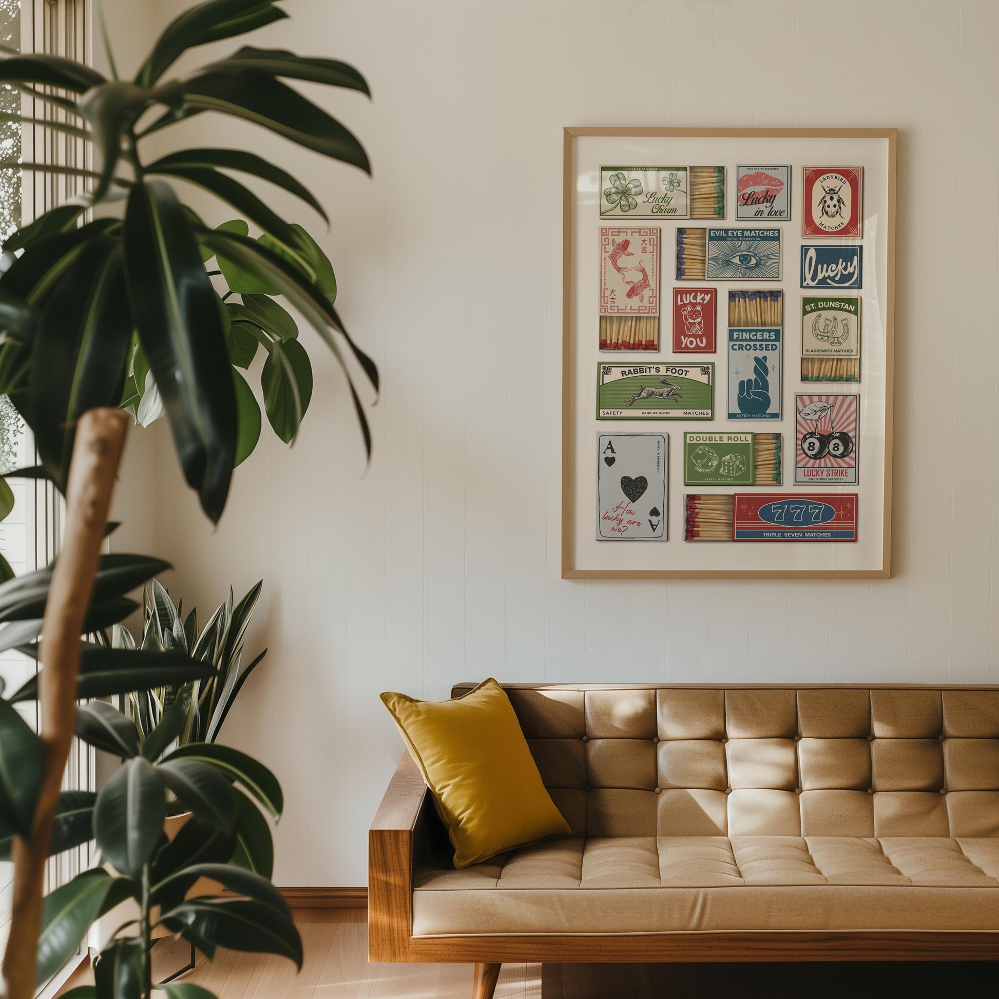 A home decor poster displaying a collage of vintage matchbook designs with diverse graphics and text, such as "Lucky" and "Fingers Crossed." The artwork hangs on a white wall above a mid-century sofa with a yellow cushion.