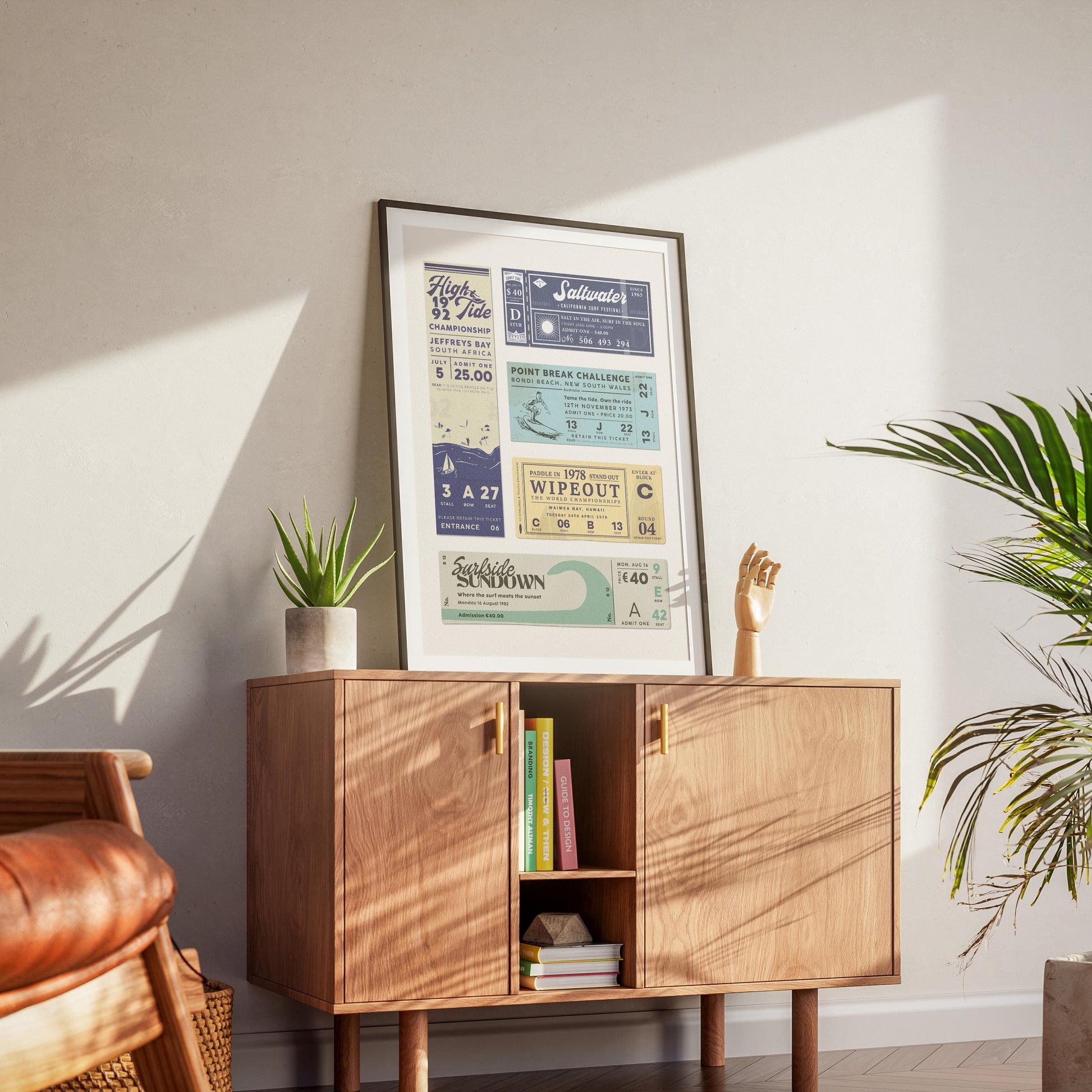 A wooden cabinet in a modern trendy home with a black frame poster on top. The surfing themed poster featured colours of blue, yellow and navy