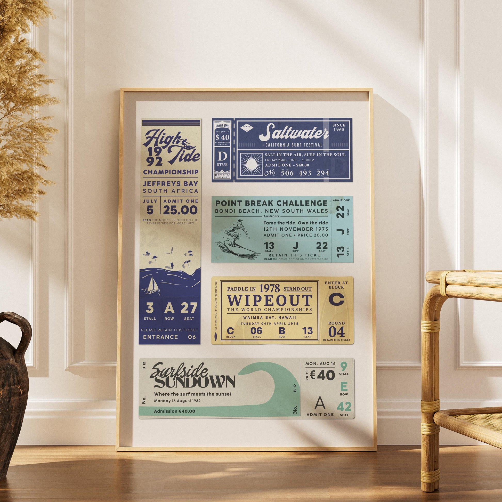 A boho home interior with a wood framed print leaning on the wall. The art is a surfing themed ticket stub motif with references to waves, surfing and the beach