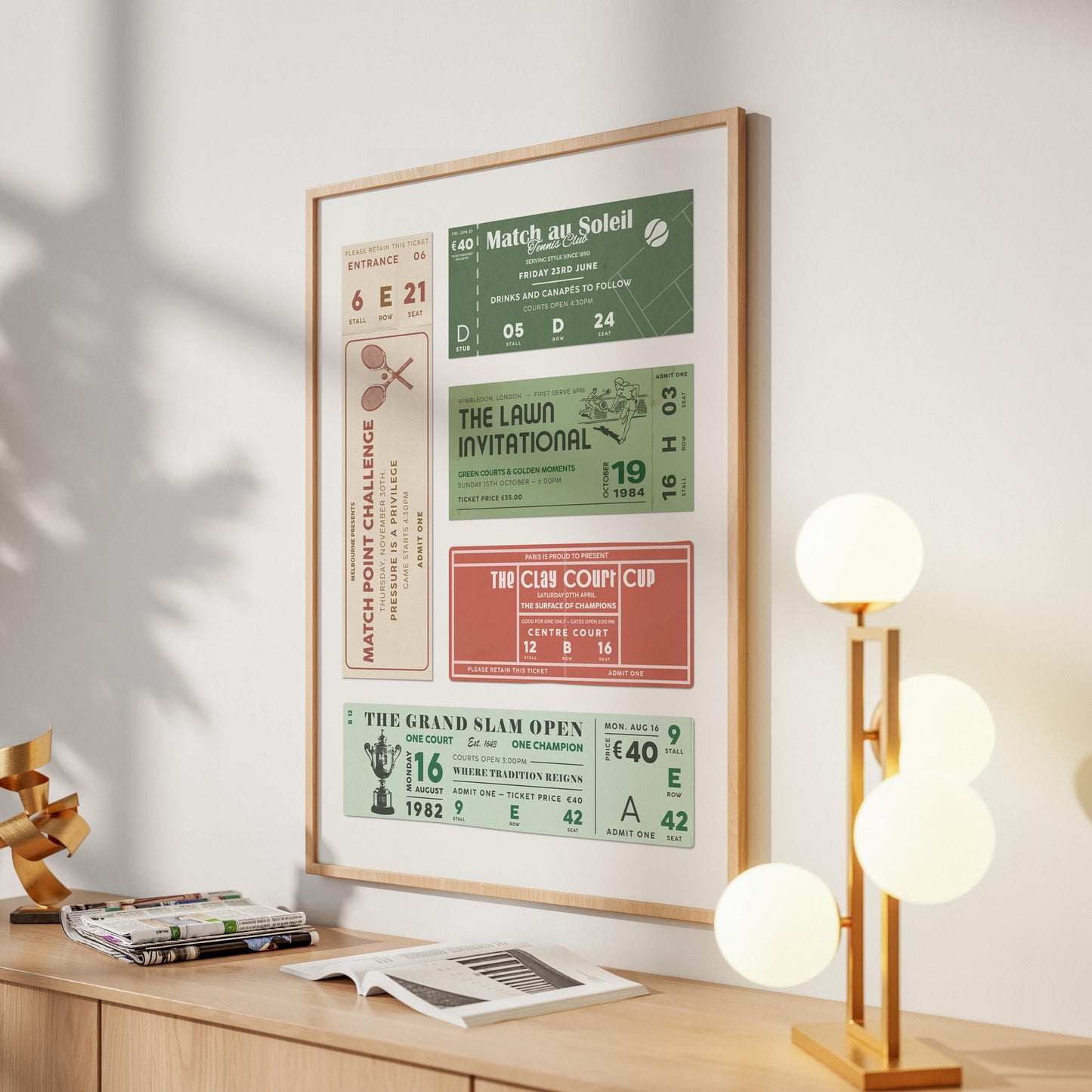An oak framed poster in a hallway of a home near a round lamp. The art is a tournament ticket stub wall art piece