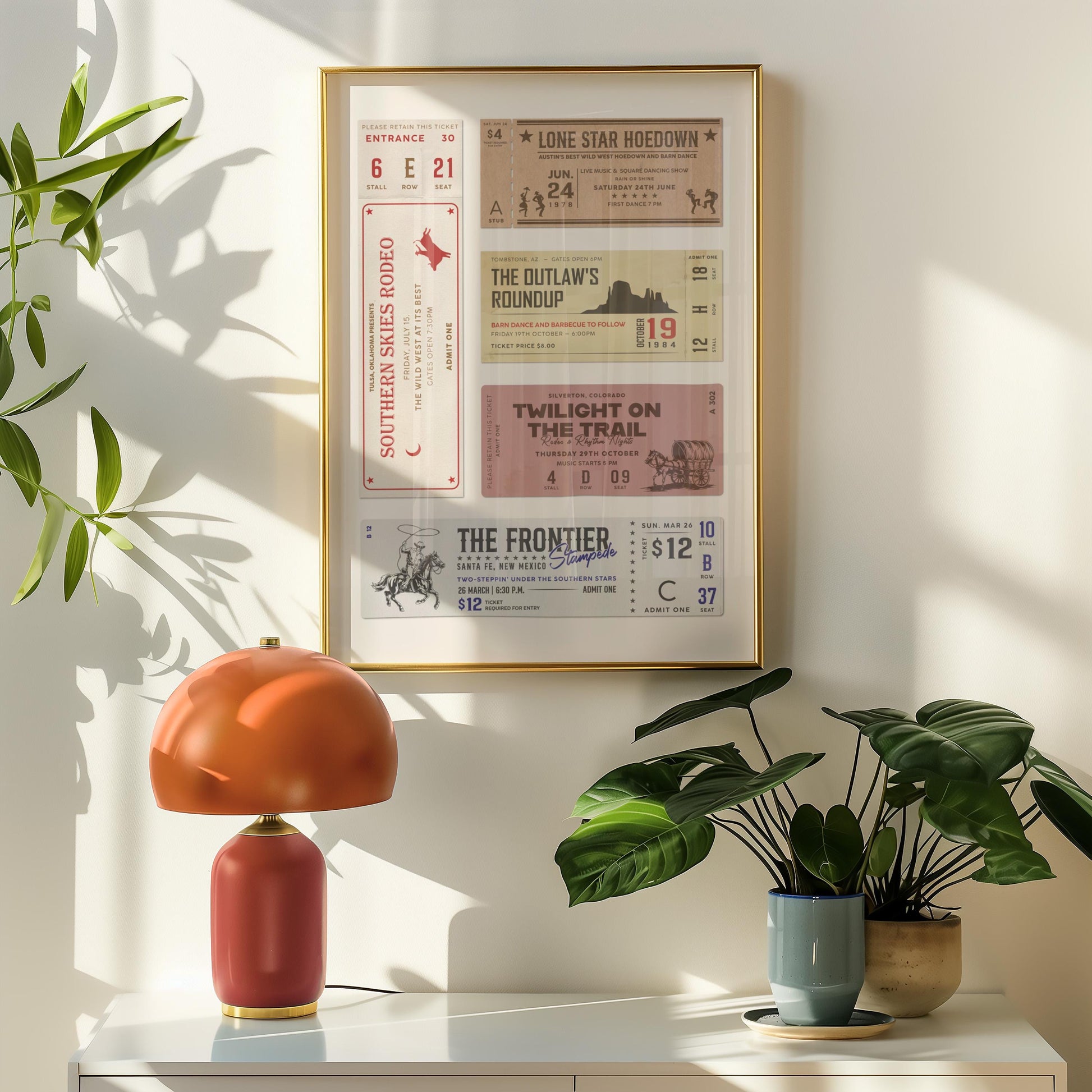 An american ranch home decor piece framed in oak on a wall with a orange lamp and potted plant visible below.
