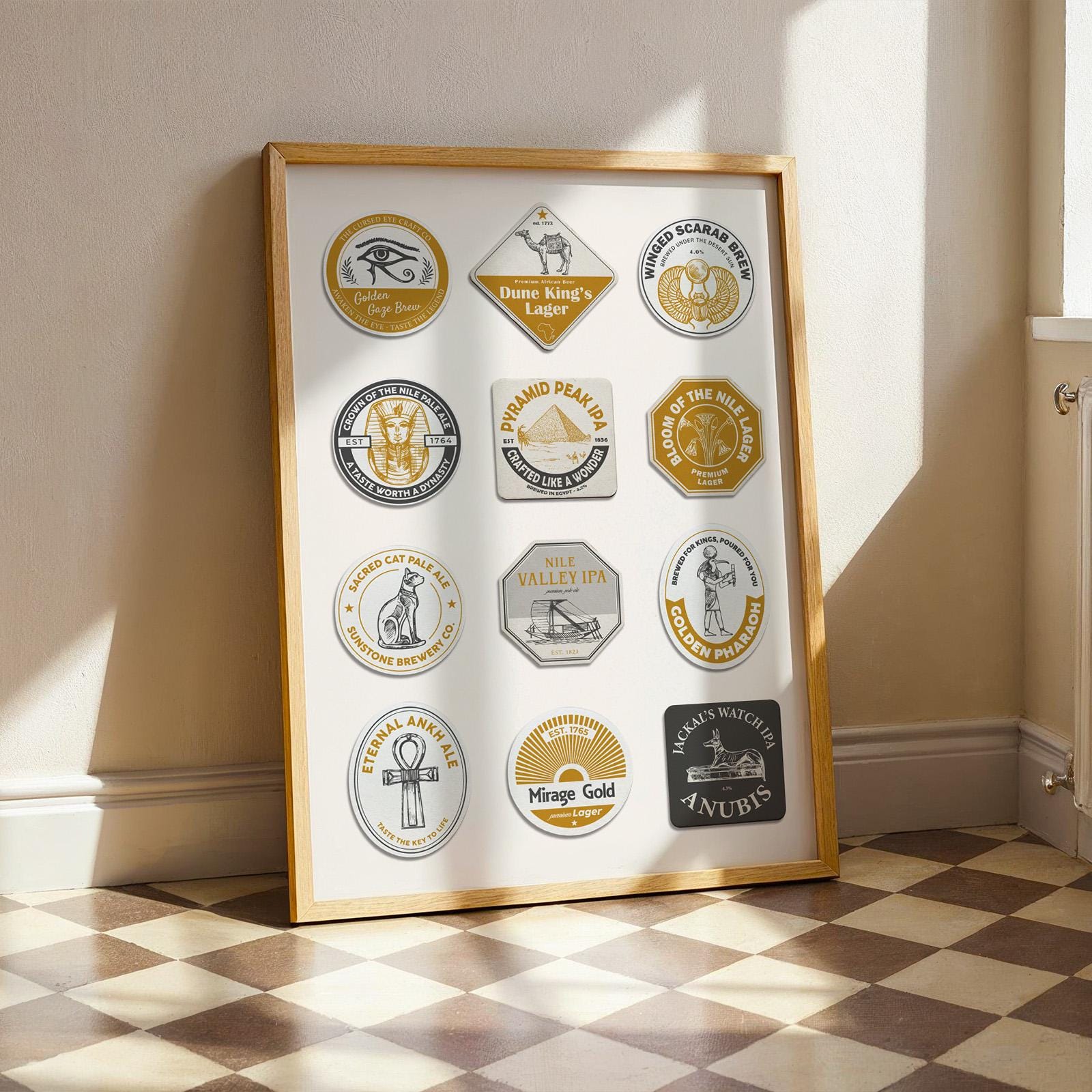 A print in a wood frame leaning on a white wall. The poster has custom made beer mats with egyptian motifs. Yellow and Blue colours with various symbols and icons such as the pyramids and camels.