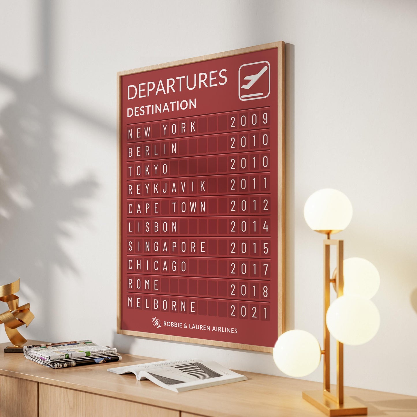 A modern girly home of a traveller with a framed art inspired by an airport information board. The print has their travels and dates on it with a custom title saying "L&R Airlines"