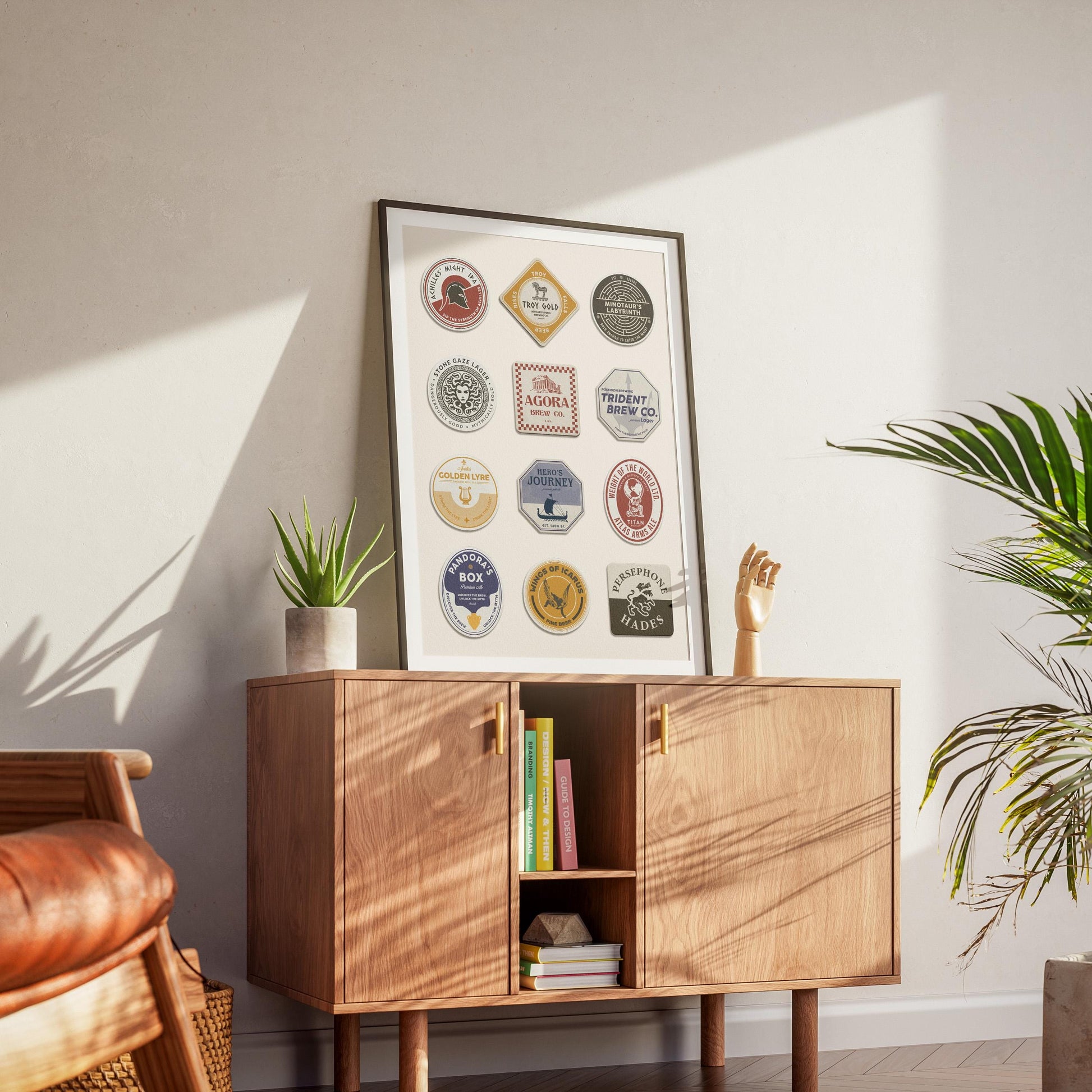 a mid century modern apartment interior with a wood cabinet and a black framed print leaning on top. The art has ancient Greek motifs of myths and gods on retro style beer mats.