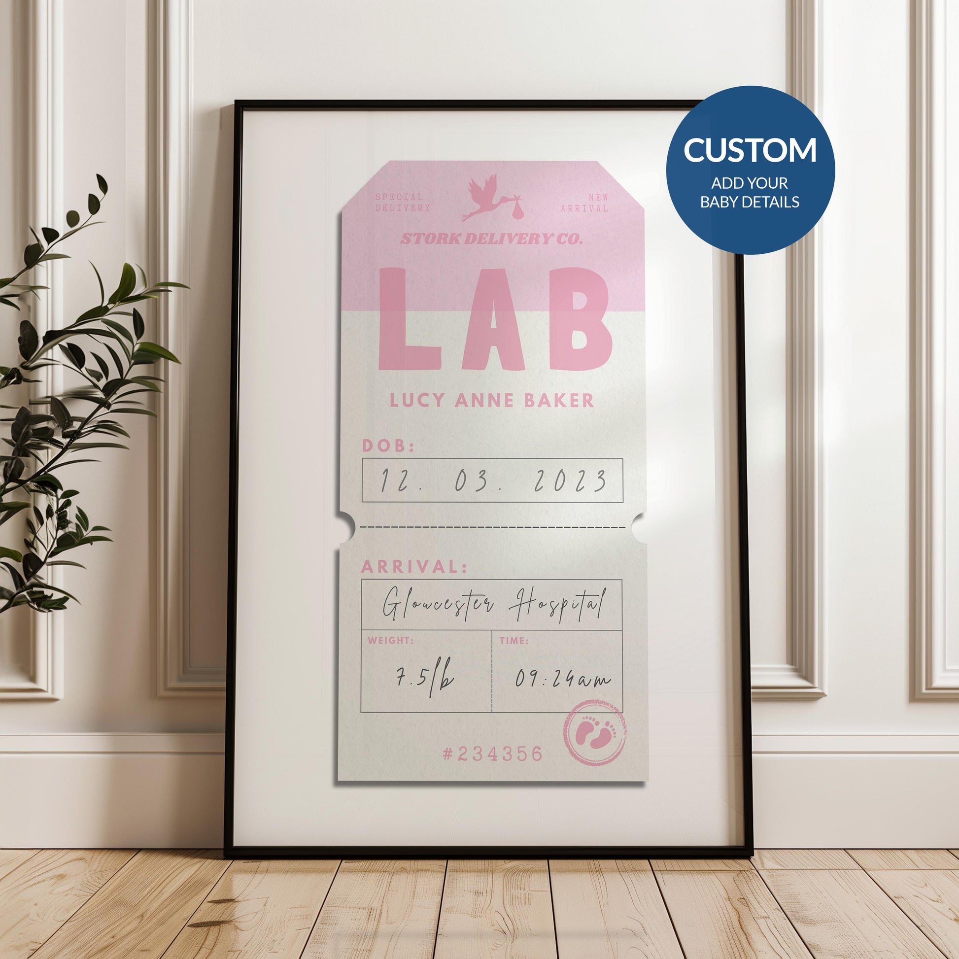 A playroom with white panelled walls and a framed print leaning on the wall. The art is a pink vintage luggage tag design with baby arrival details on it such as name, weight and time of birth.