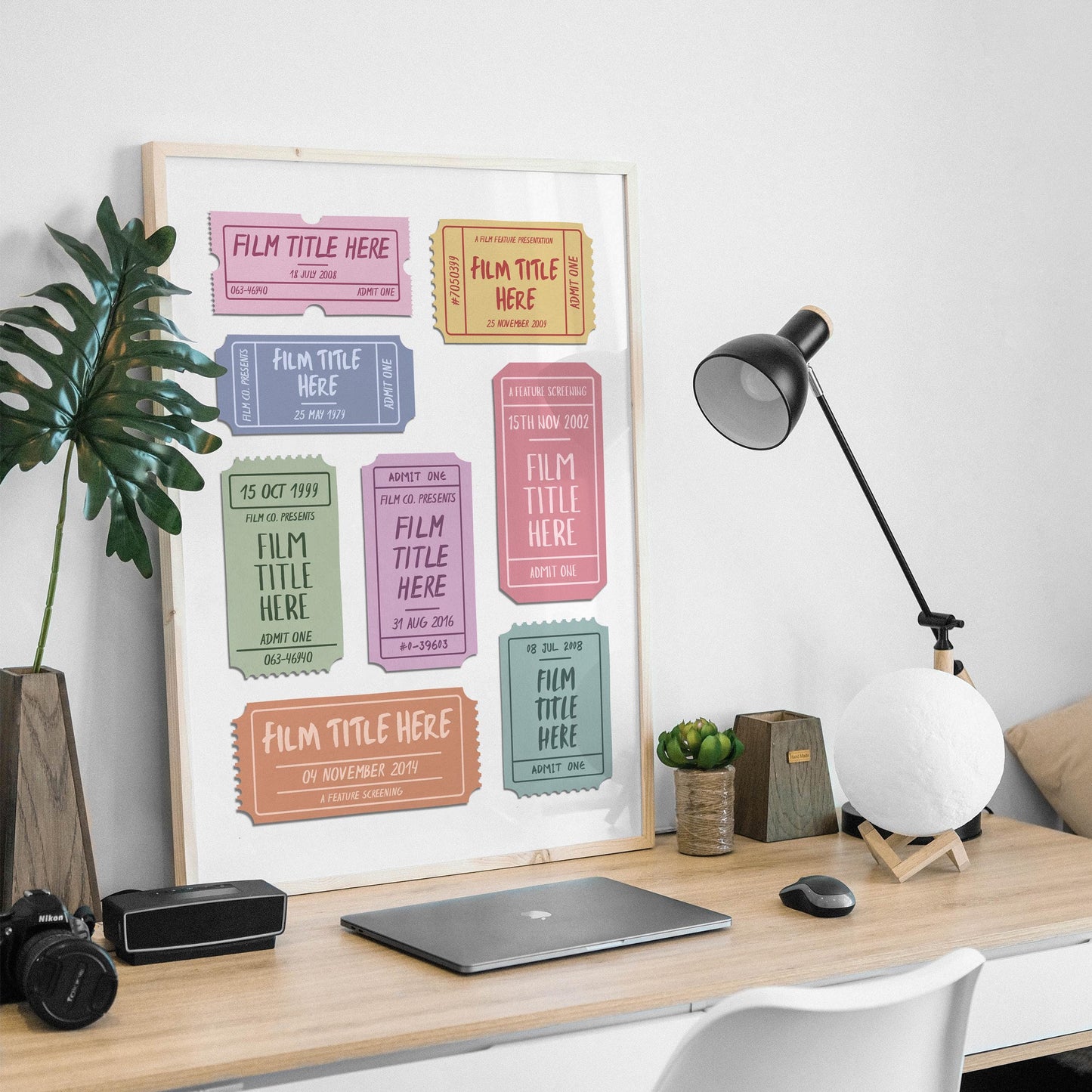 A masculine desk setup at home with old ticket stubs art framed on counter.