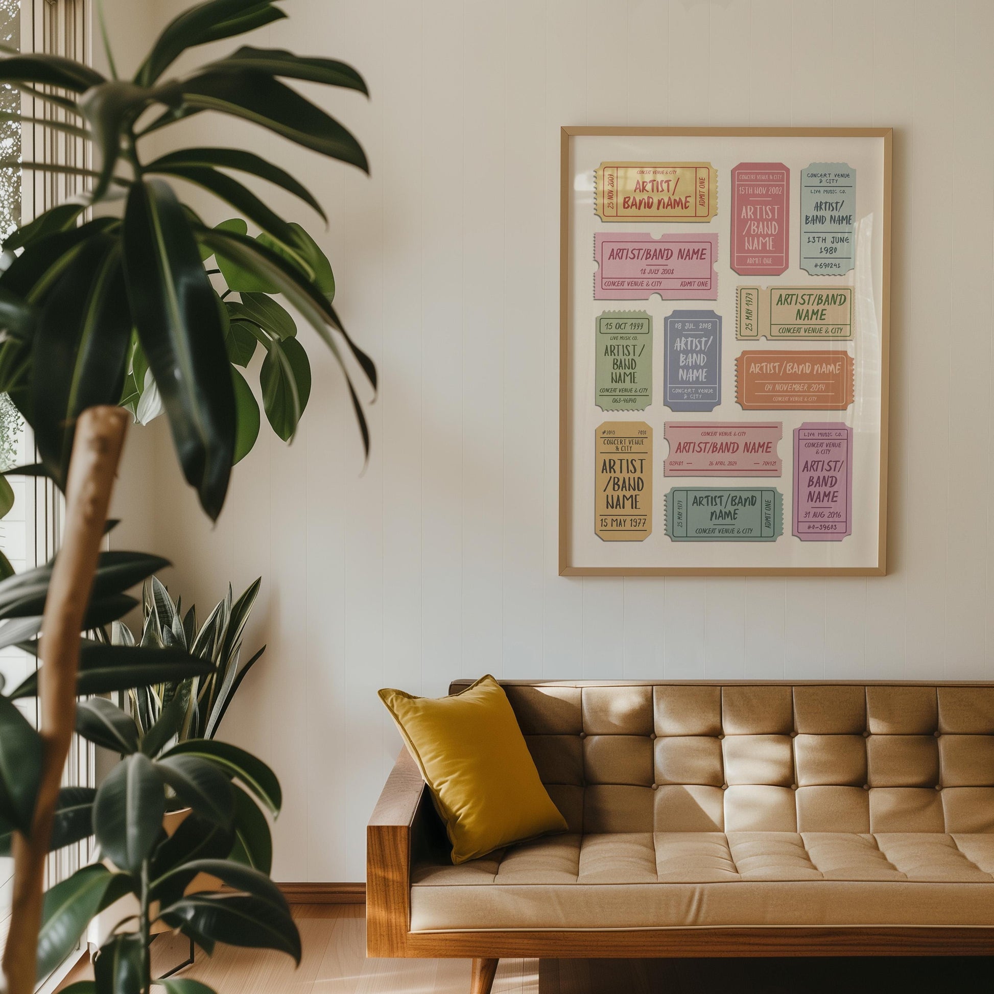 A customisable worn ticket stub wall art for girly pastel music fans is on the wall in a mid century modern home with a brown leather sofa.