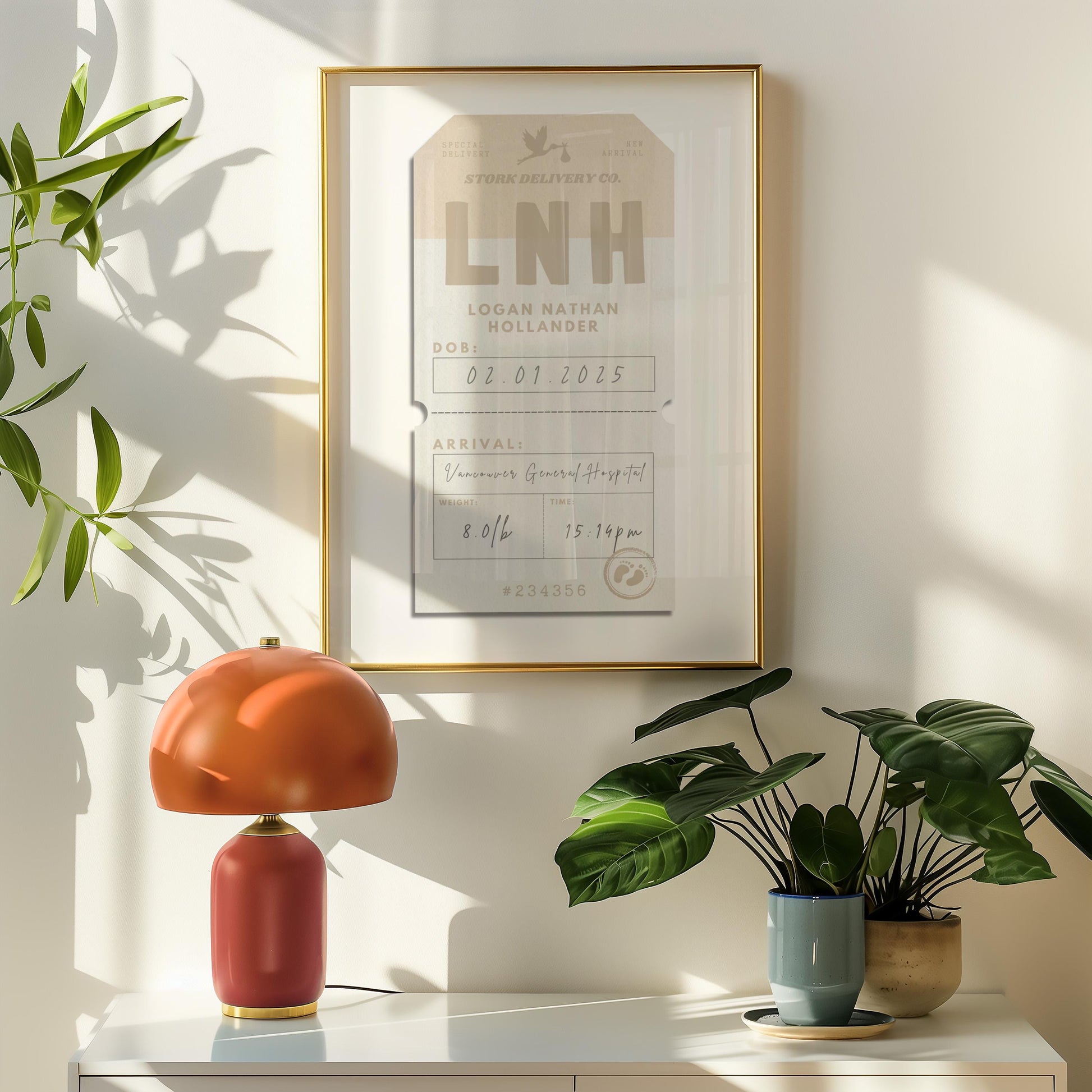 A beige and brown luggage tag framed on the wall in a retro style home with an orange lamp and plant on a shelf. The art is hung on the wall and has the title stork delivery co and features babies stats from birth such as arrival time and date.