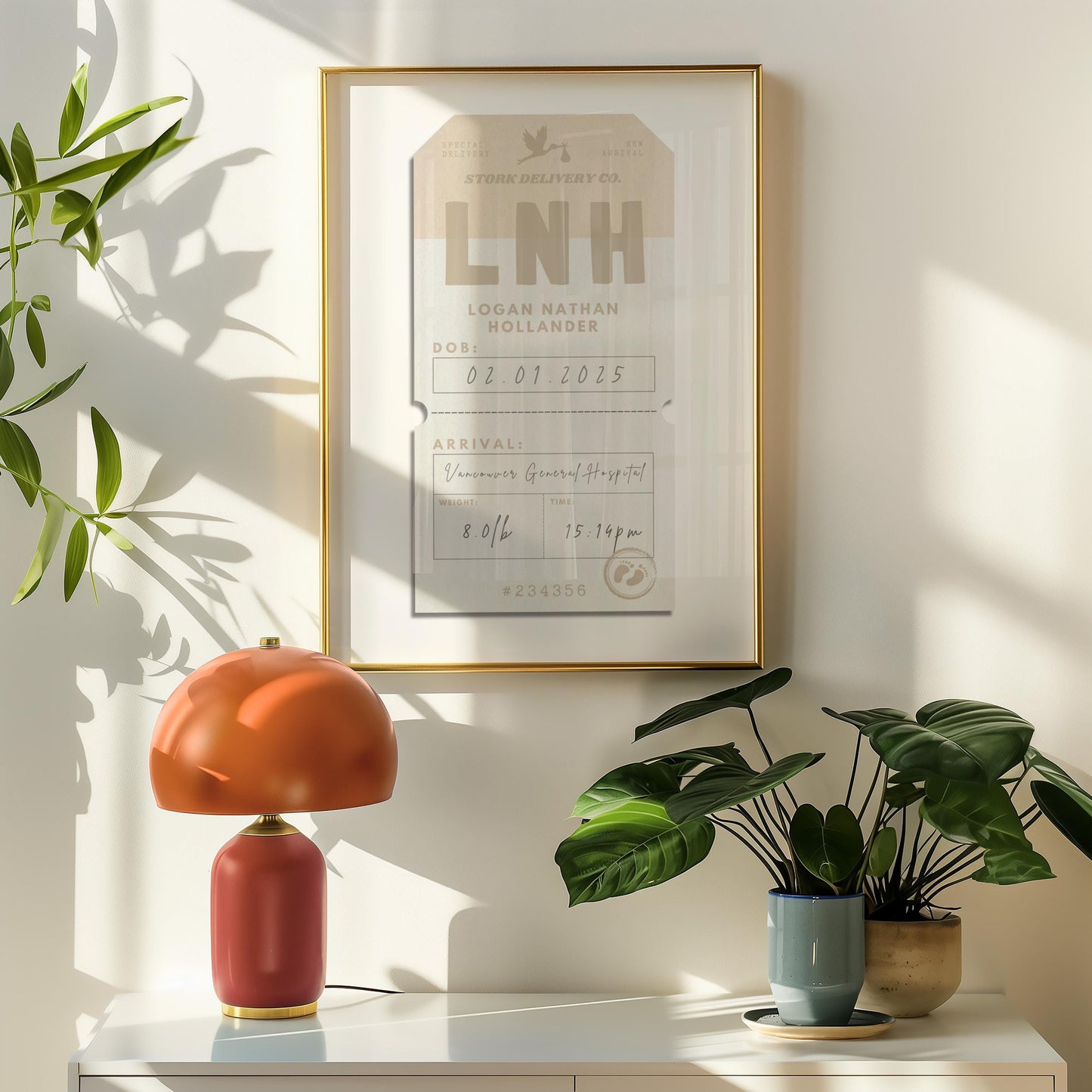 A beige and brown luggage tag framed on the wall in a retro style home with an orange lamp and plant on a shelf. The art is hung on the wall and has the title stork delivery co and features babies stats from birth such as arrival time and date.