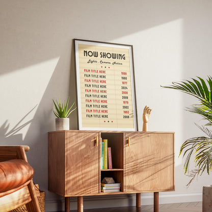 A mid century modern office with a cream colour vintage movie art print, personalized with family favourite films leaning on the wall on a wood sideboard.