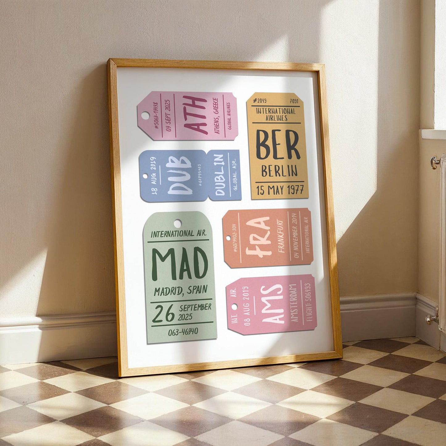 A checkerboard floor kitchen in a well lit space. A print is leaning on the wall showing a set of vintage luggage tags with custom details and destinations on them.