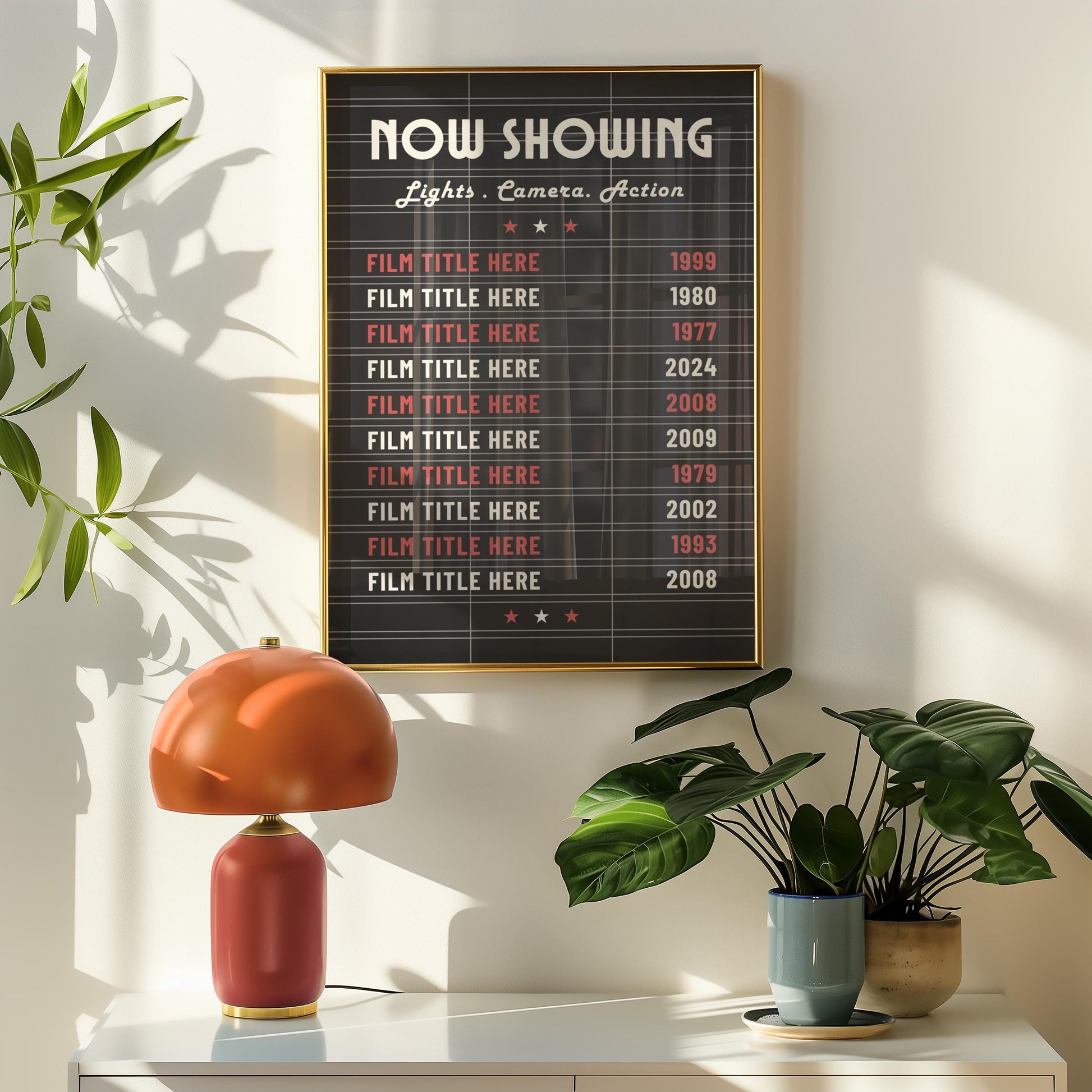 A retro hallway with a orange lamp and plant on a sideboard. Above is a black lightbox inspired cinema billboard print showing a selection of old classic films.