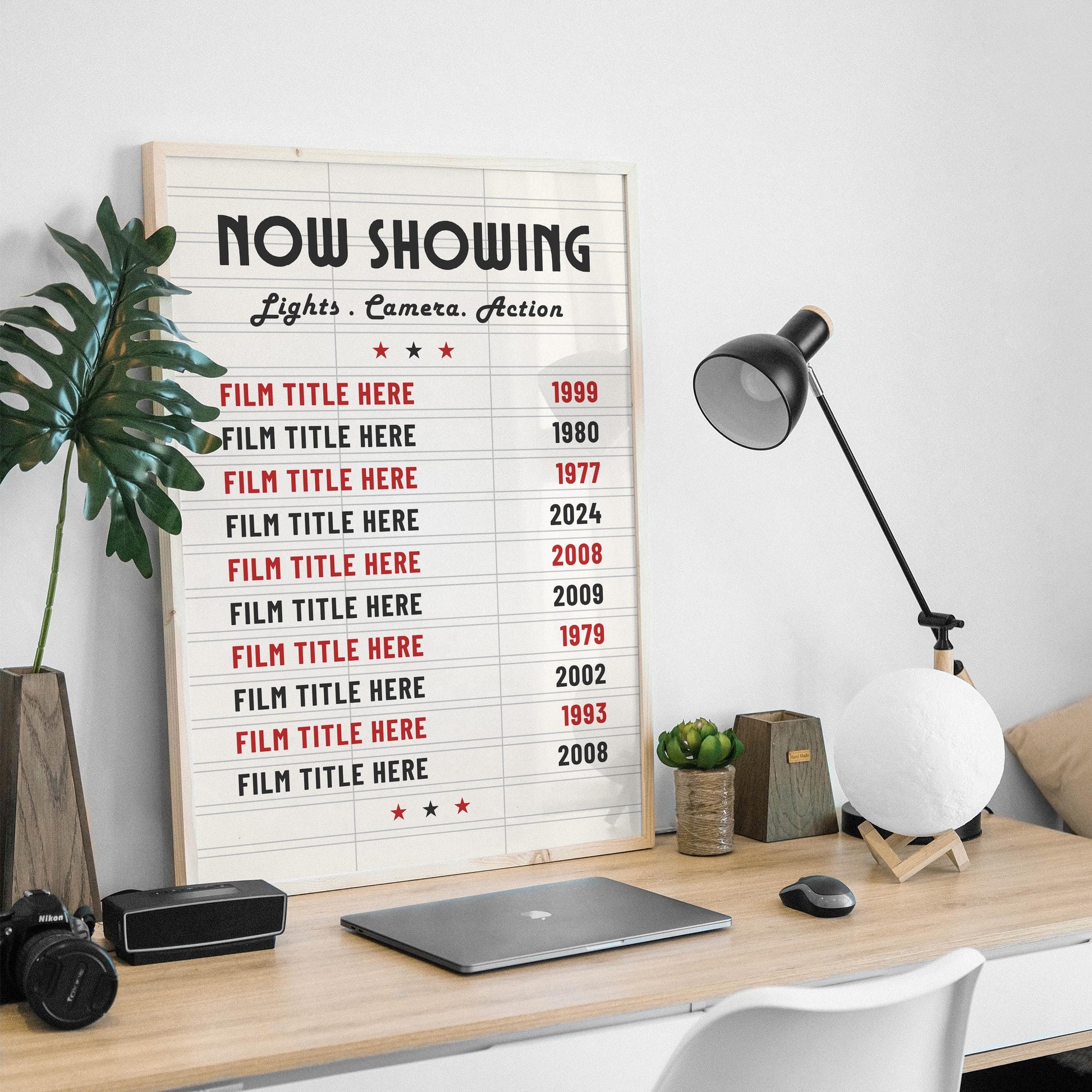 A masculine desk setup in a home office with old film memorabilia keepsake art on the wall. The print resembles an old move theatre letterboard.