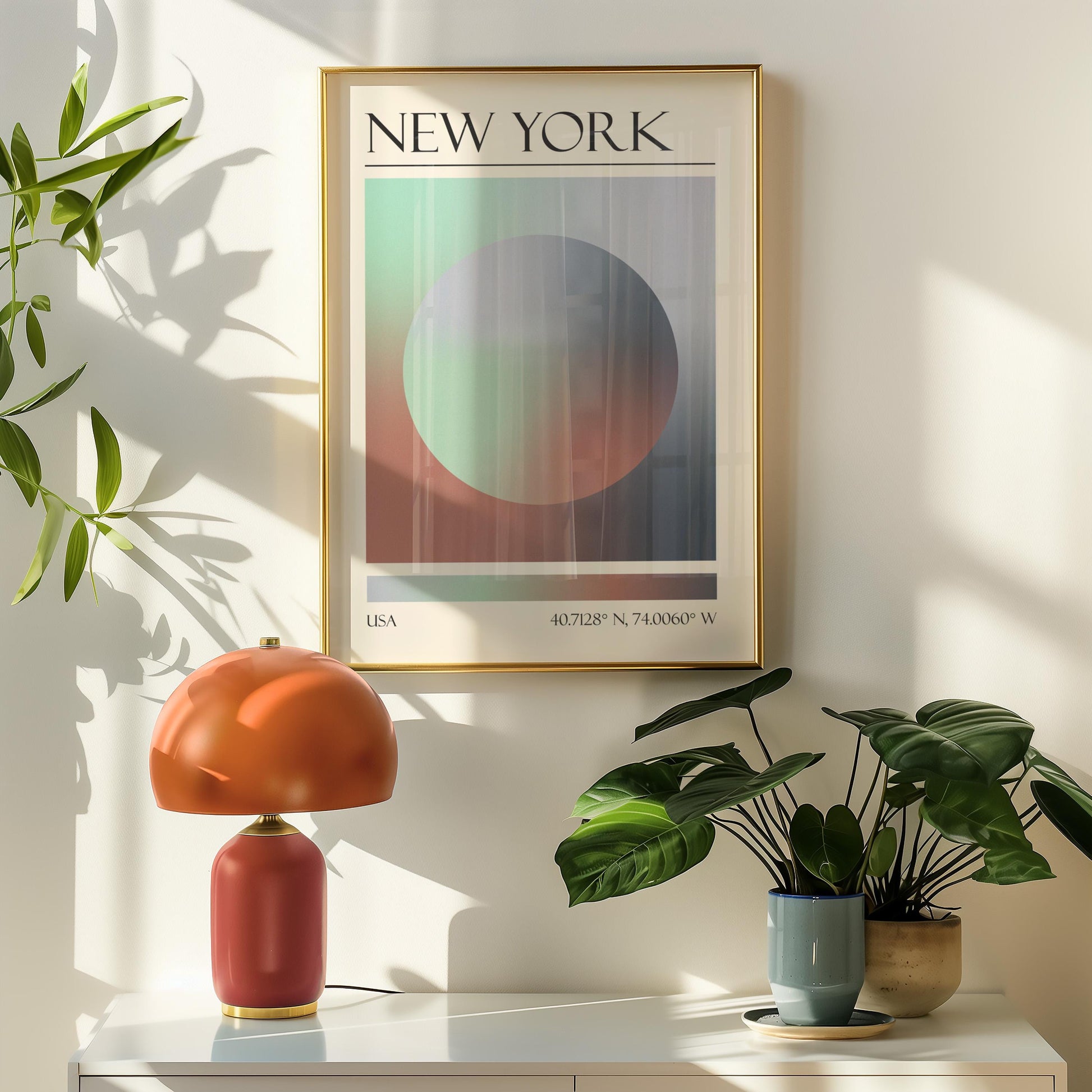 A framed travel poster featuring a geometric aura inspired design in shades of green, grey, and pink hangs above a orange table lamp. Potted plants are on the right.