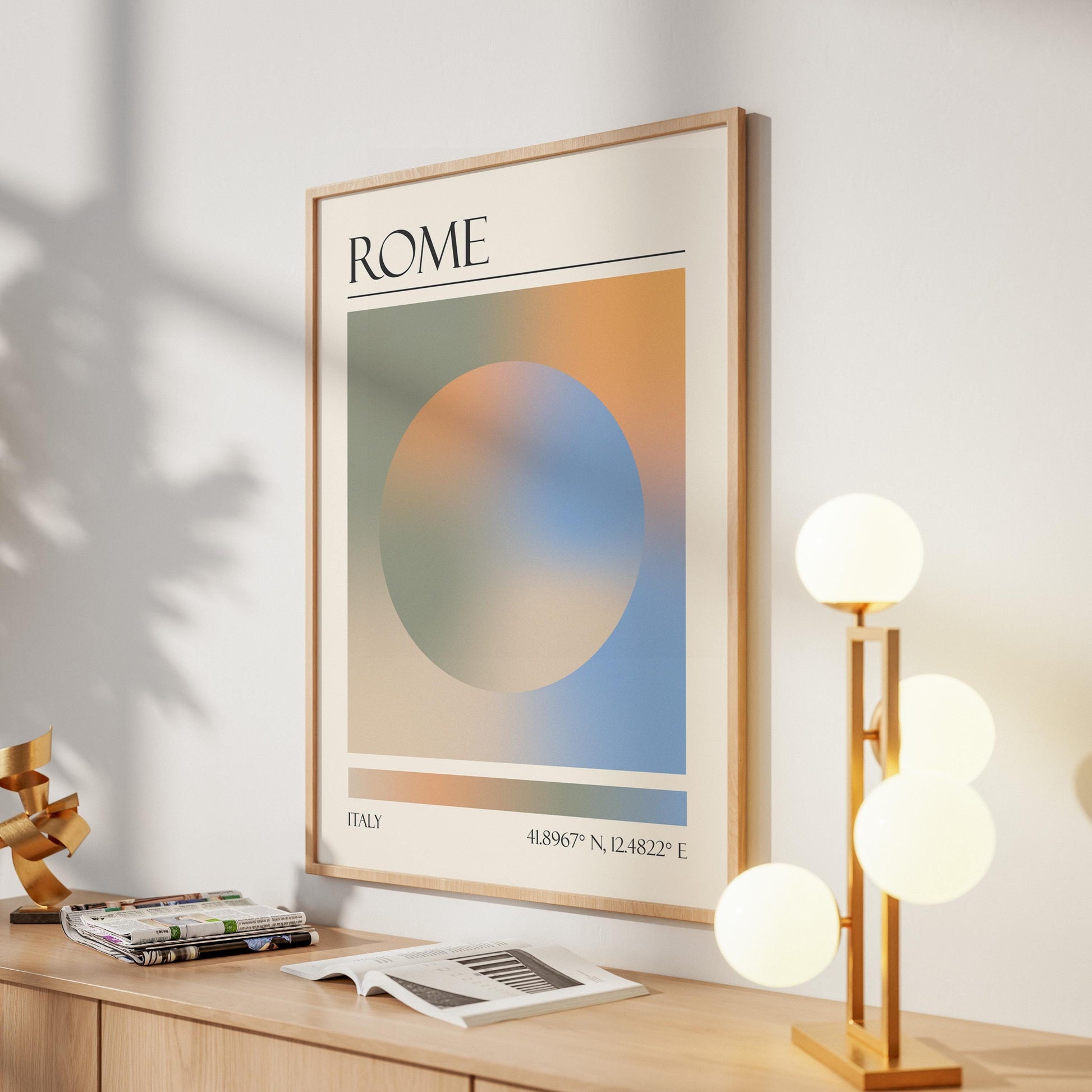 A framed print with the word "ROME" at the top. The destination artwork features a colourful aura circle in teal, orange, blue and beige. A gold lamp with four white globe lights is to the right in the hallway.