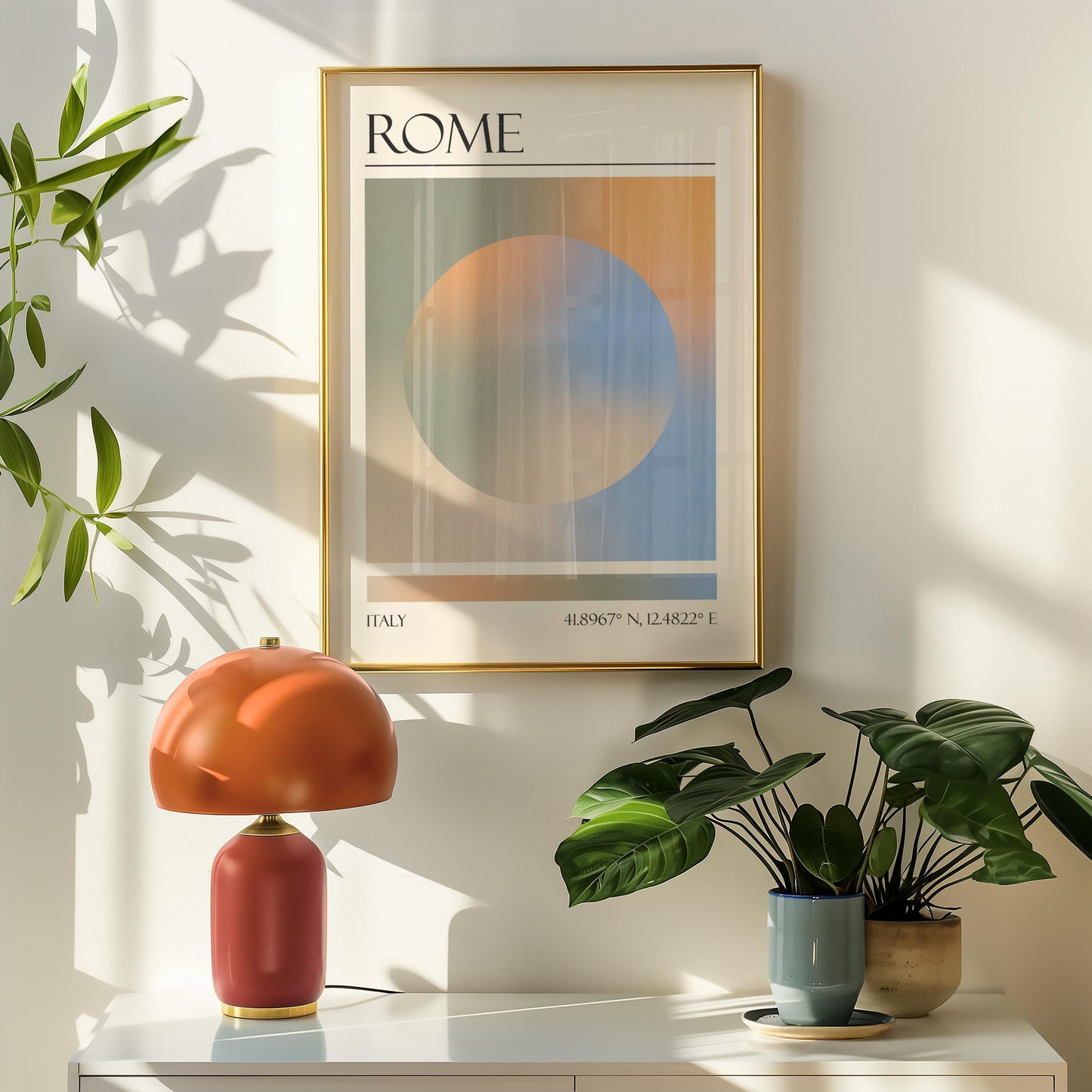 A framed travel poster featuring a geometric aura inspired design in shades of blue, orange, green and beige hangs above a orange table lamp. Potted plants are on the right.