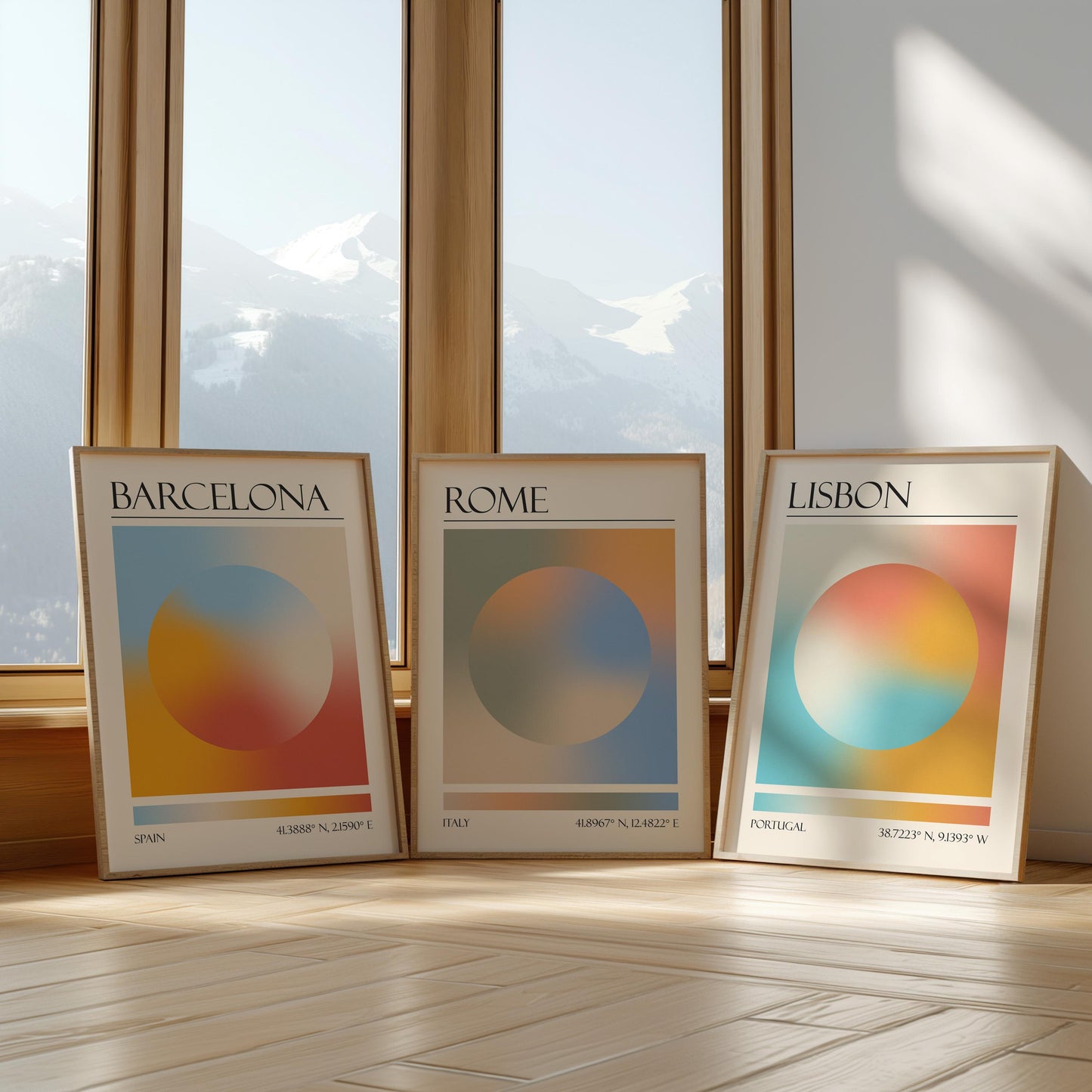 Three framed art prints with abstract designs and gradient colour palettes. The set of three triptych prints each display a city name: Rome, Barcelona, and Lisbon. The prints are in neutral-toned wooden frames, leaning against a window.