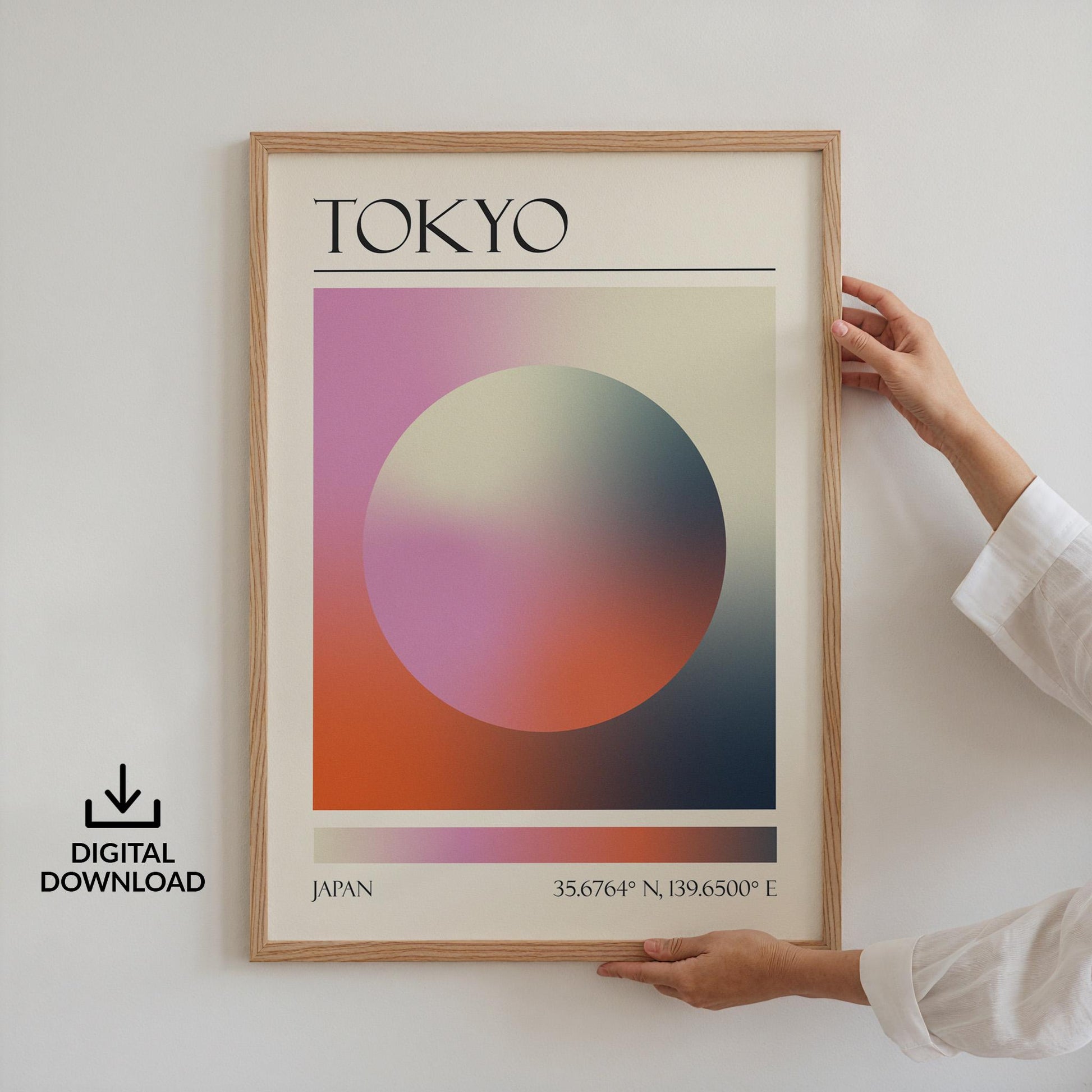 Someone in a white top holding up a framed print on the wall. The art is a destination travel poster inspired by spiritual aura colours inspired by the location such as Tokyo.