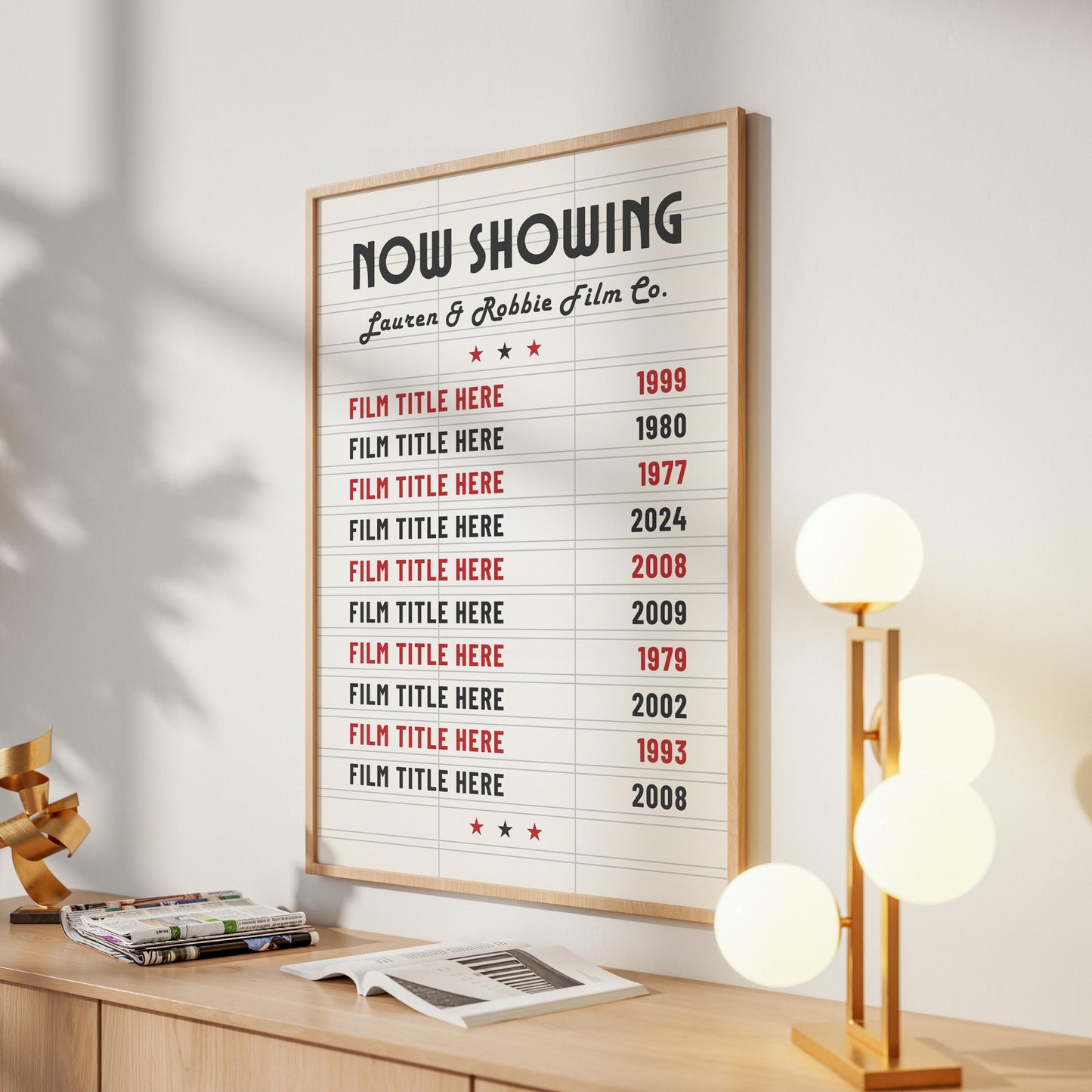 A minimalist home setting in a hallway with a modern round lamp. On the wall is a vintage style personalised home cinema favourites art print. Custom text says "Lauren & Robbie Film Co."