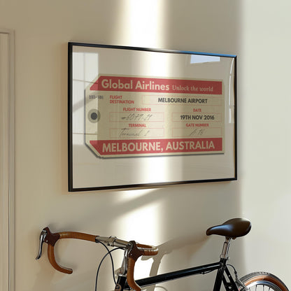 A Parisian flat hallway with a bike leaning on the wall and a framed print hung on the wall. The art is a personalised keepsake of a luggage tag with custom details on it