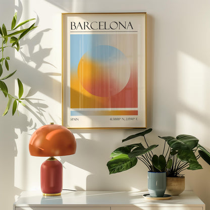 A framed travel poster featuring a geometric aura inspired design in shades of blue, orange, and red hangs above a orange table lamp. Potted plants are on the right.