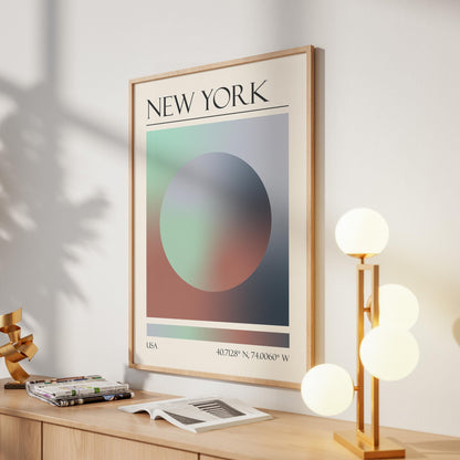 A framed print with the word "NEW YORK" at the top. The destination artwork features a colourful aura circle in teal, grey, and pink. A gold lamp with four white globe lights is to the right in the hallway.