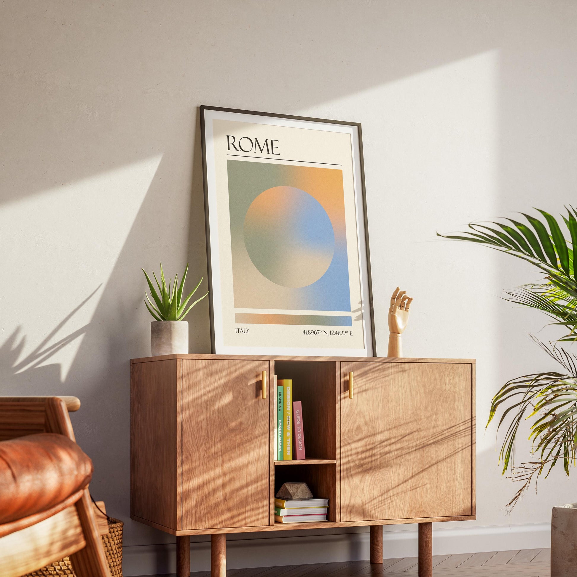 A black frame with an aura gradient circle print inside. The word "ROME" and coordinates are at the bottom. The memory keepsake print is displayed on a wooden cabinet with gold handles.
