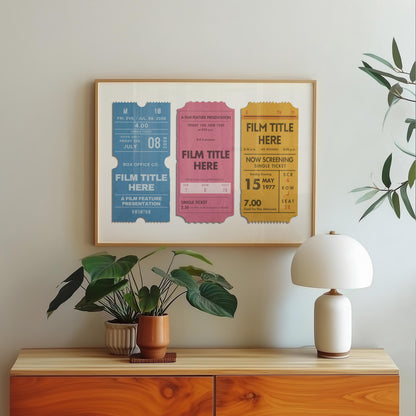 A bedroom with a wood chest of draws plant and lamp. Hung on the wall is a wood framed poster with a design of cinema ticket stubs of a couples special events and favourite films.