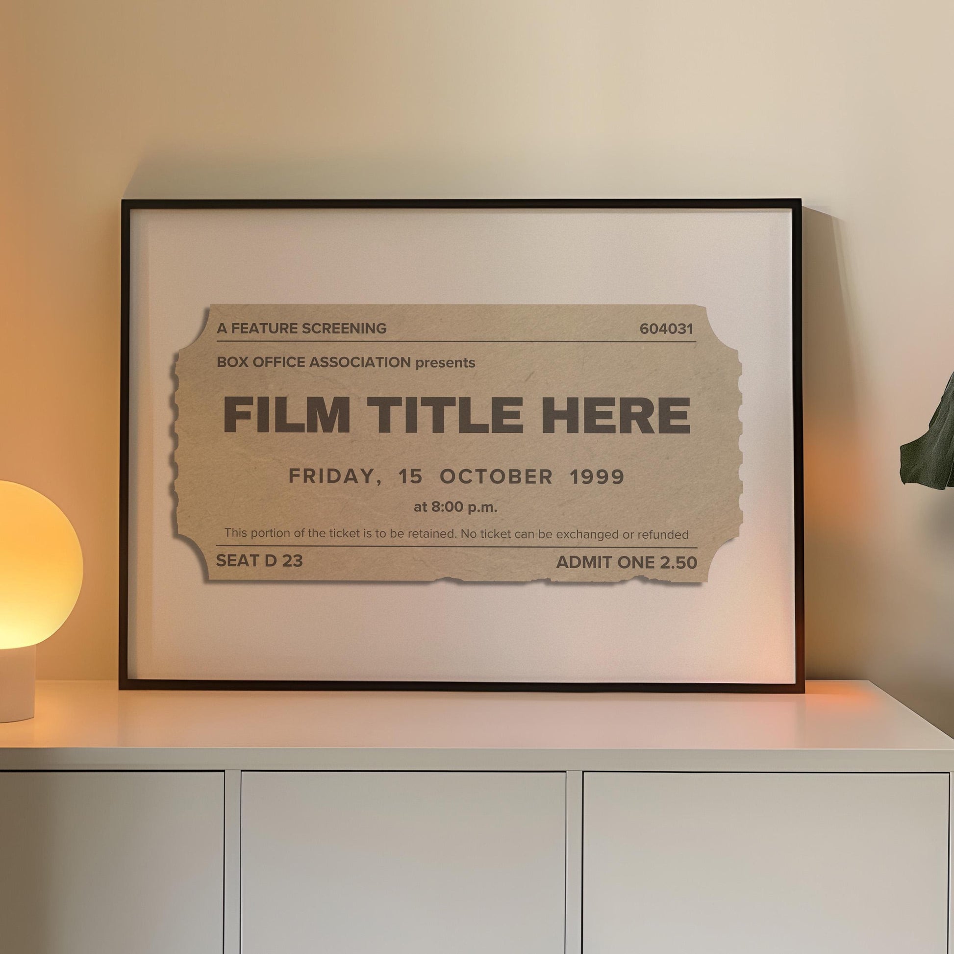 A cosy Livingroom with warm lighting and a large horizontal frame leaning on the wall. The art is minimalist and bespoke made inspired by old movie theatre tickets