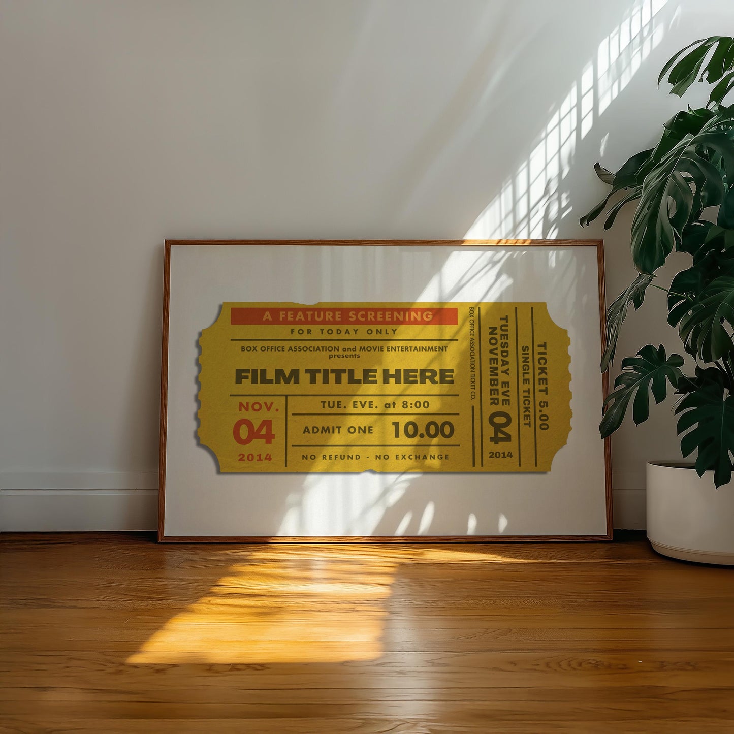 A well lit hallway with a poster leaning on the wall in a wood framing. The poster shows a designed old movie theatre stub with a bespoke film title on it.