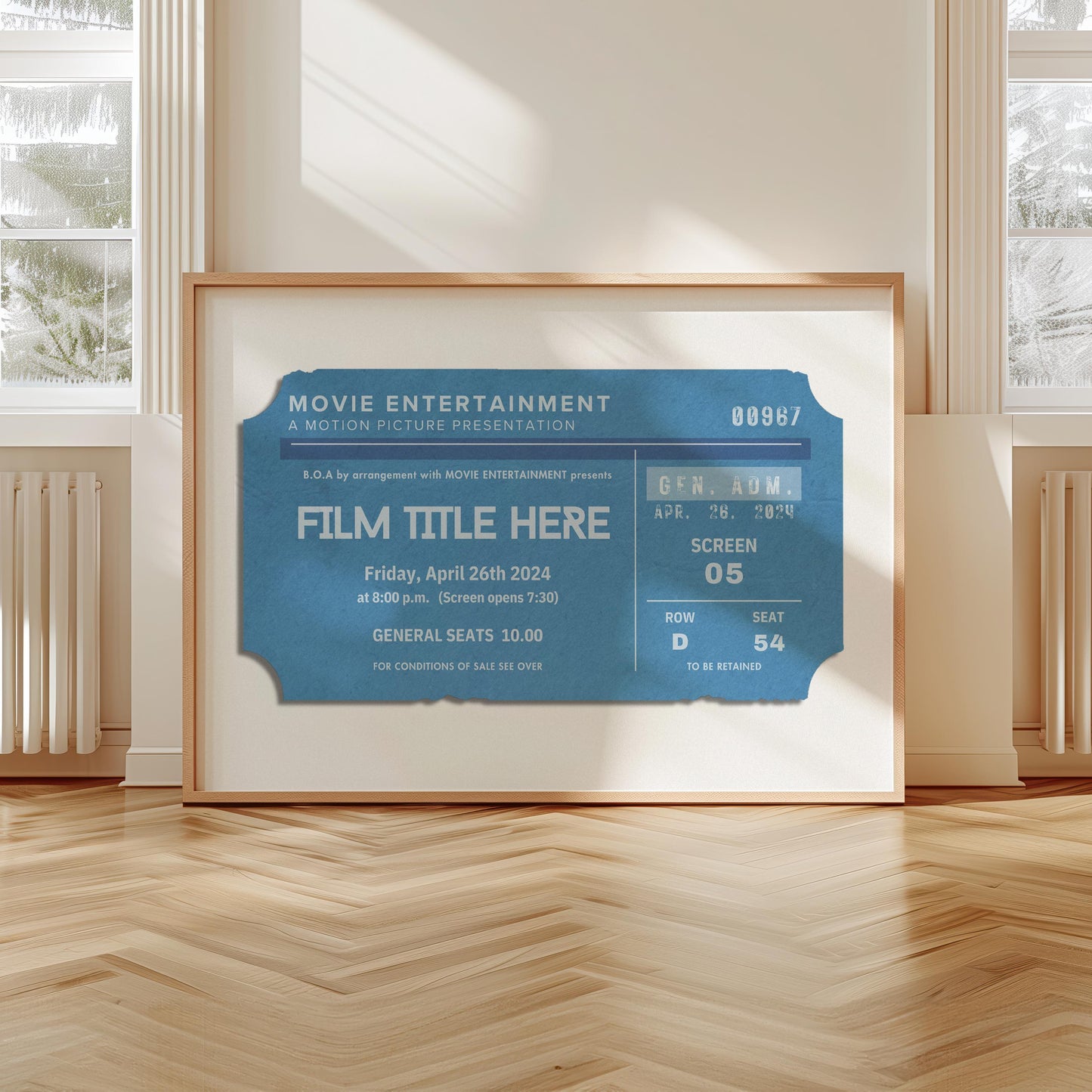 A bright minimal scandi living room with a large landscape print leaning on the wall. The art is a vintage navy movie ticket stub with perosnalised text on it