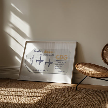 A natural bedroom with rattan rug and chair. A poster is in a white frame near a window showing an old luggage tag design which has been made bespoke with personalised text.