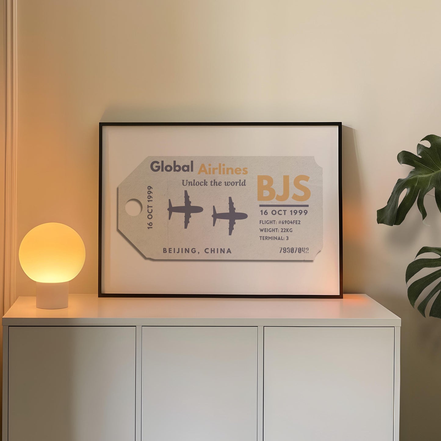 A cosy bedroom with a round lamp and plant on a counter. A black frame contains a bespoke poster with an airport travel theme.